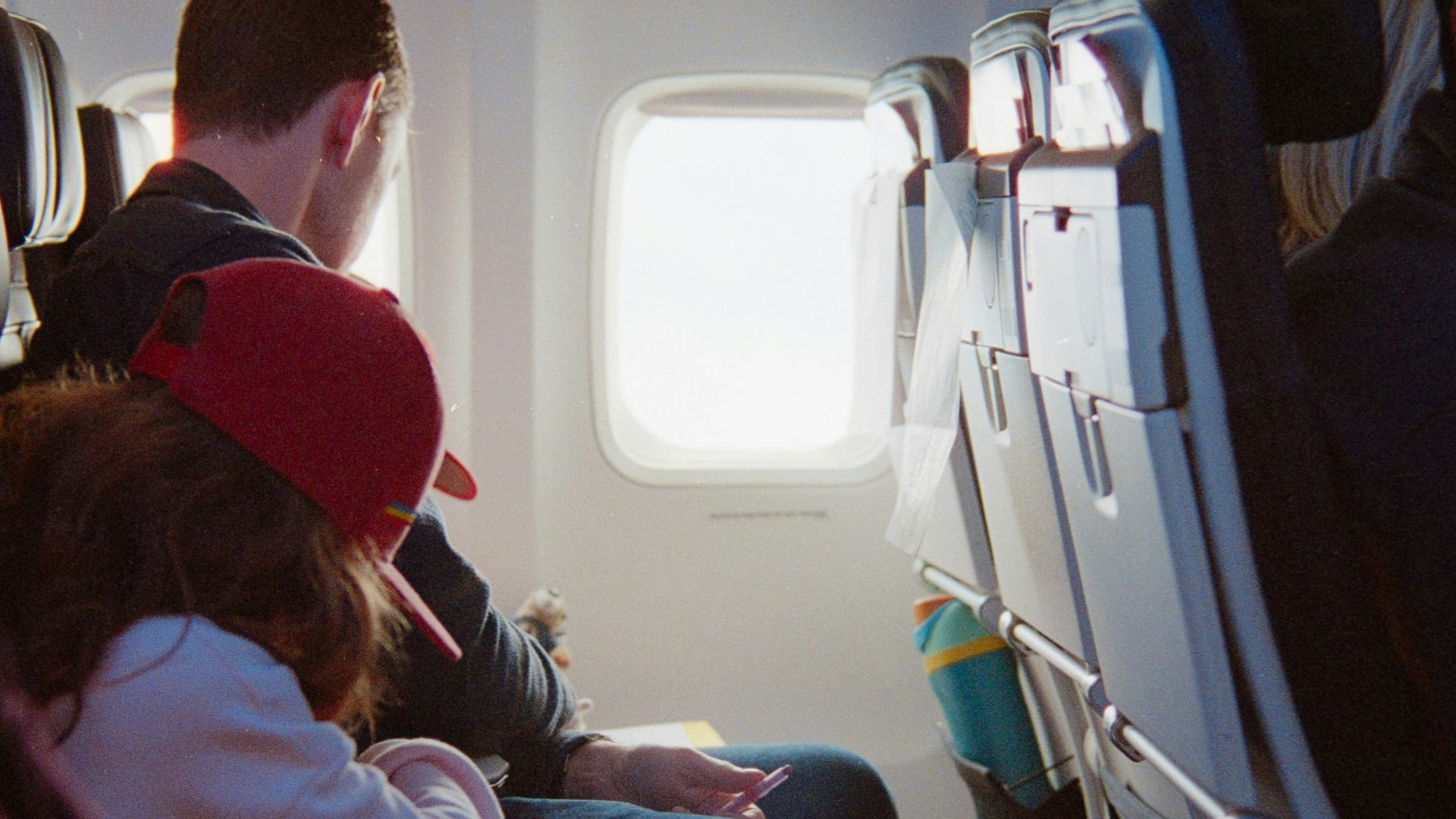 Passengers seated inside an airplane cabin during flight.