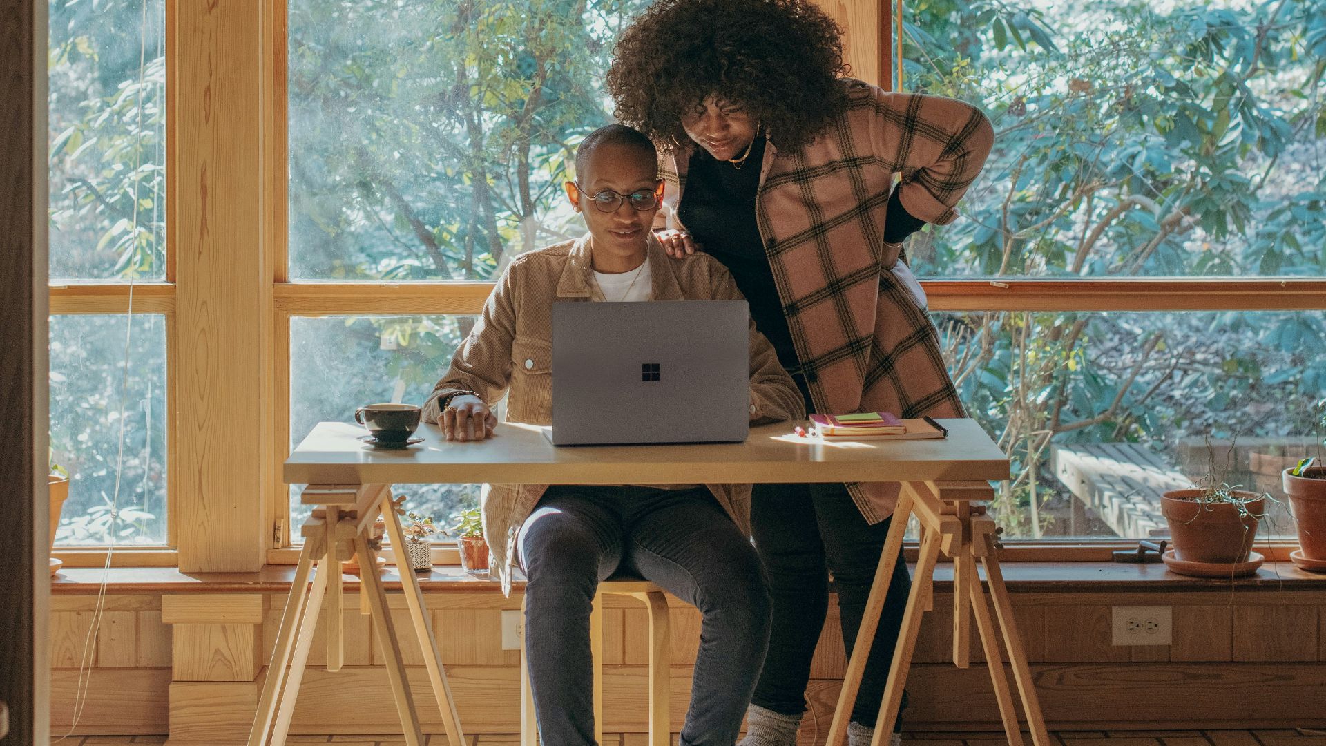 person sitting on chair in front of table with Surface device