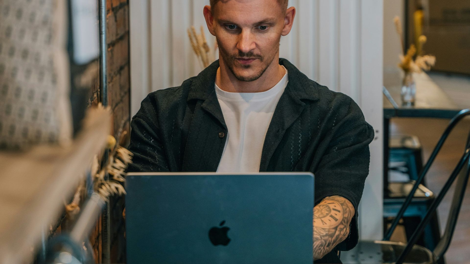 A man sitting at a table using a laptop computer