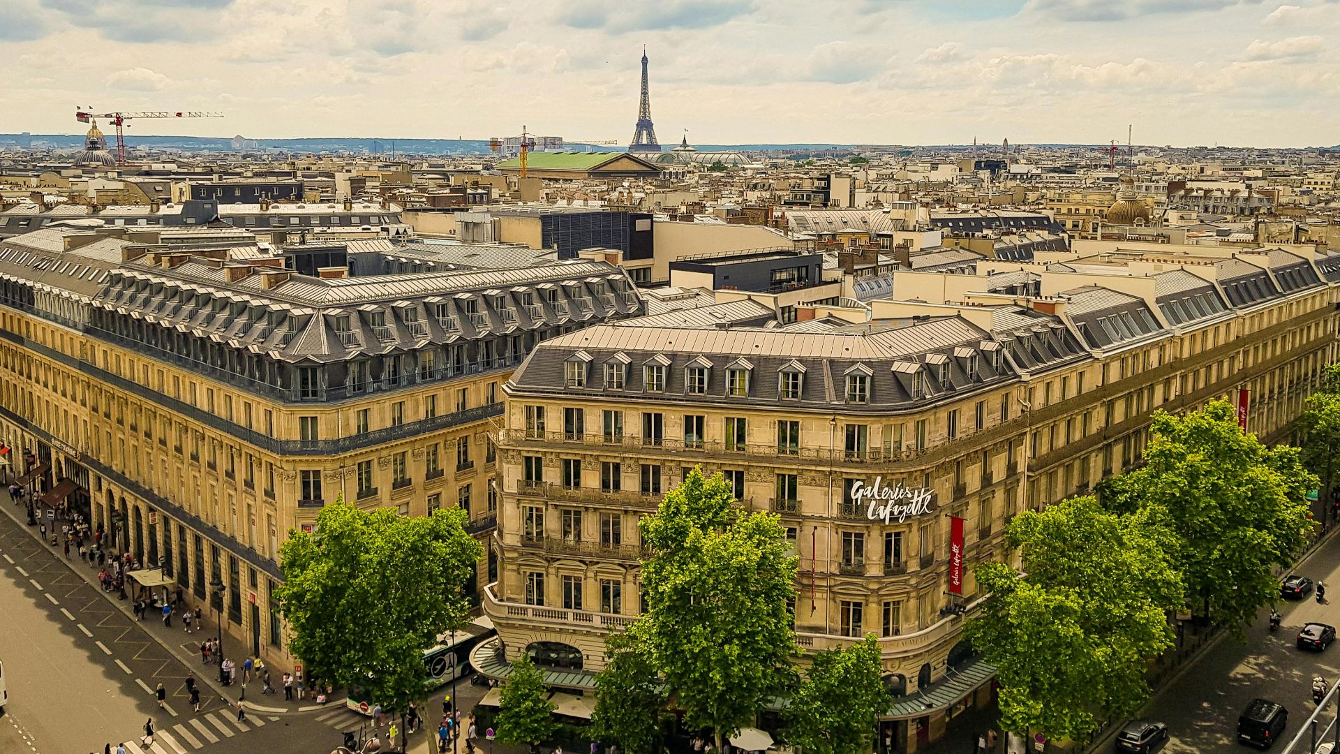 Aerial view of Paris with Galeries Lafayette and Eiffel Tower in the background.