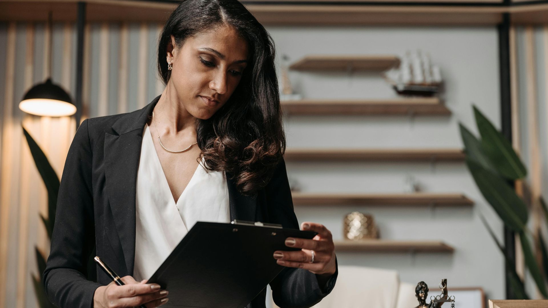 Confident businesswoman reviewing paperwork in a modern law office setting.