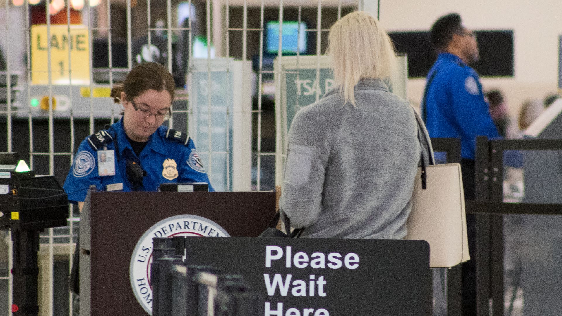 A Transportation Security Administration agent at a checkpoint verifying passenger identification, John Glenn Columbus International Airport