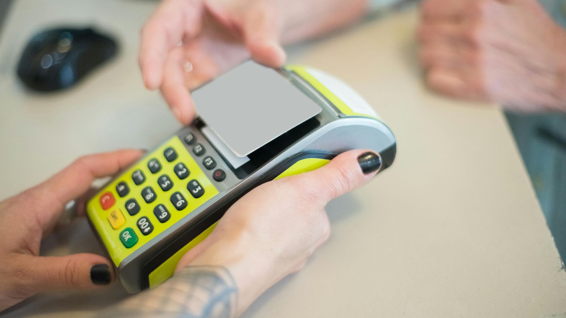 Hands engaging in a secure card transaction with a payment terminal, capturing the essence of modern business transactions.