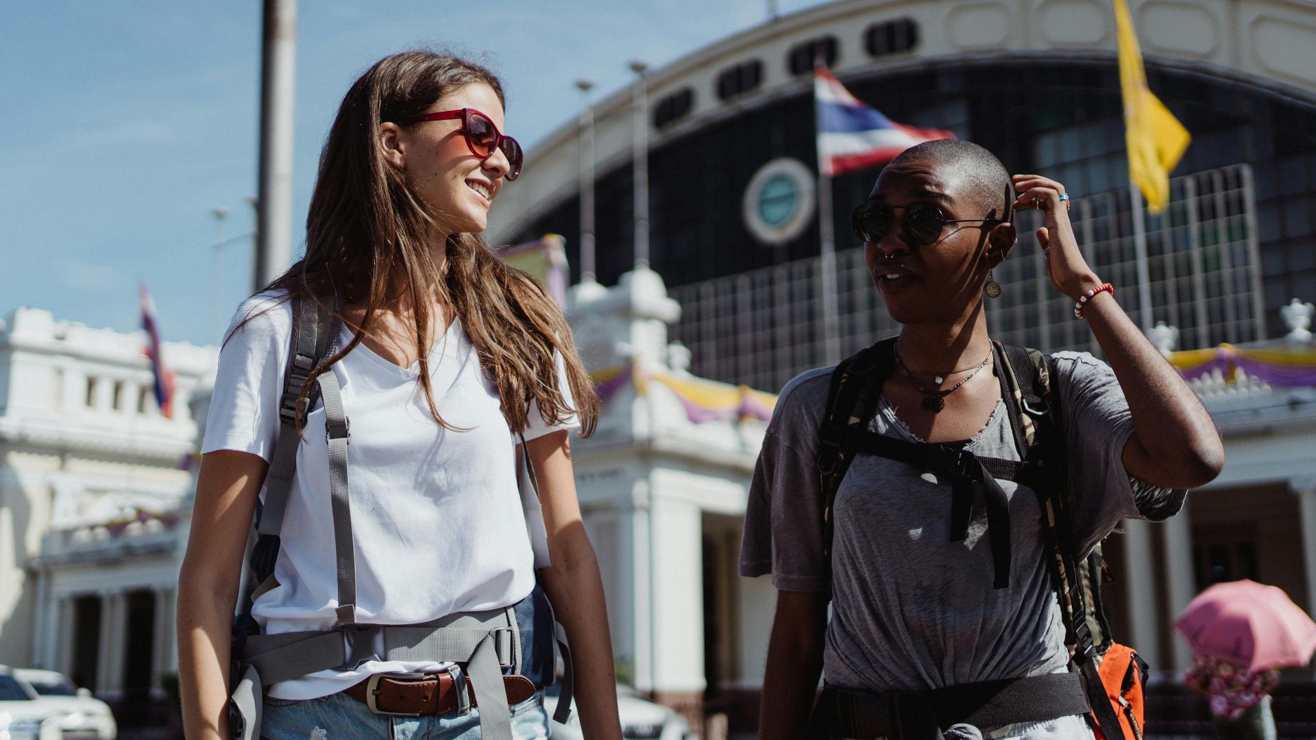 Two women travelers enjoying a sunny day exploring a new city.