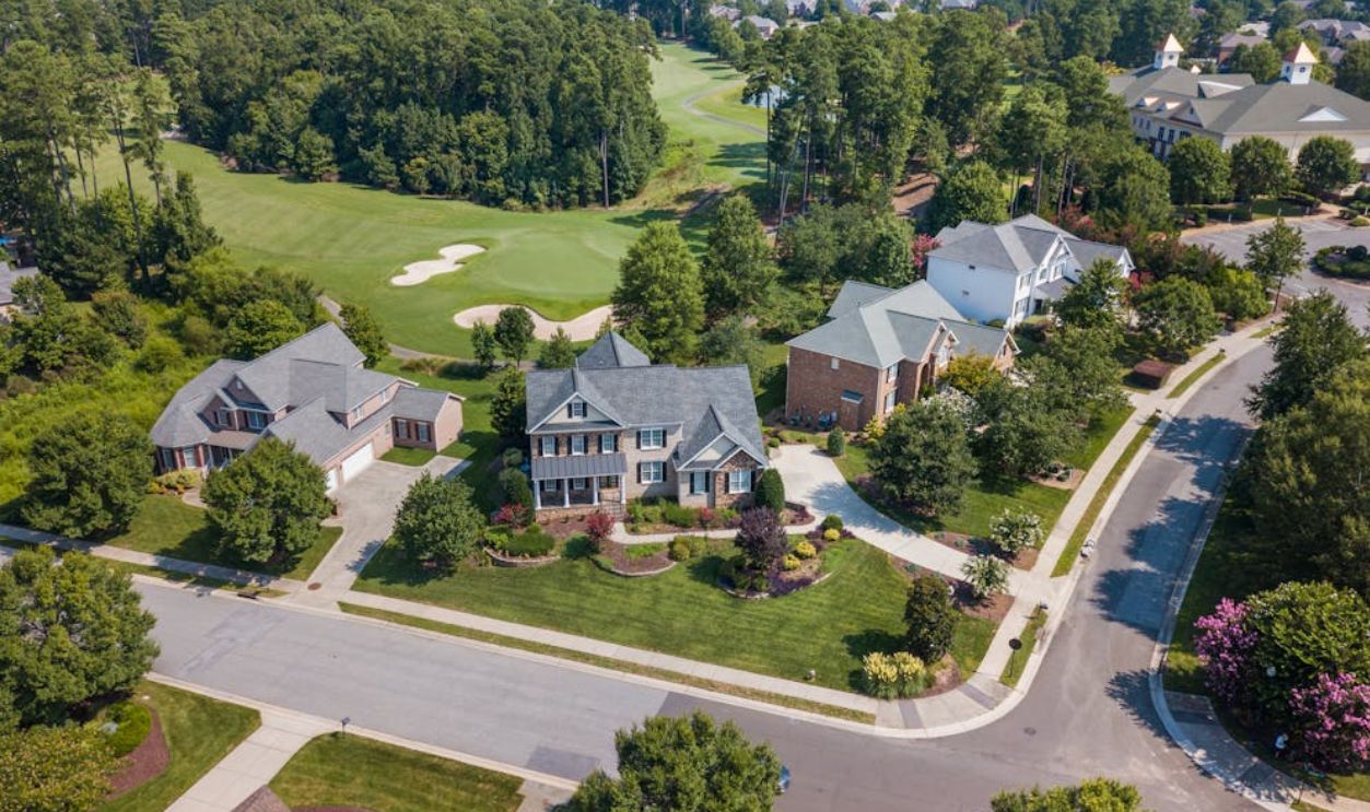 Aerial view of suburban neighborhood with lush greenery and golf course in Raleigh, NC
