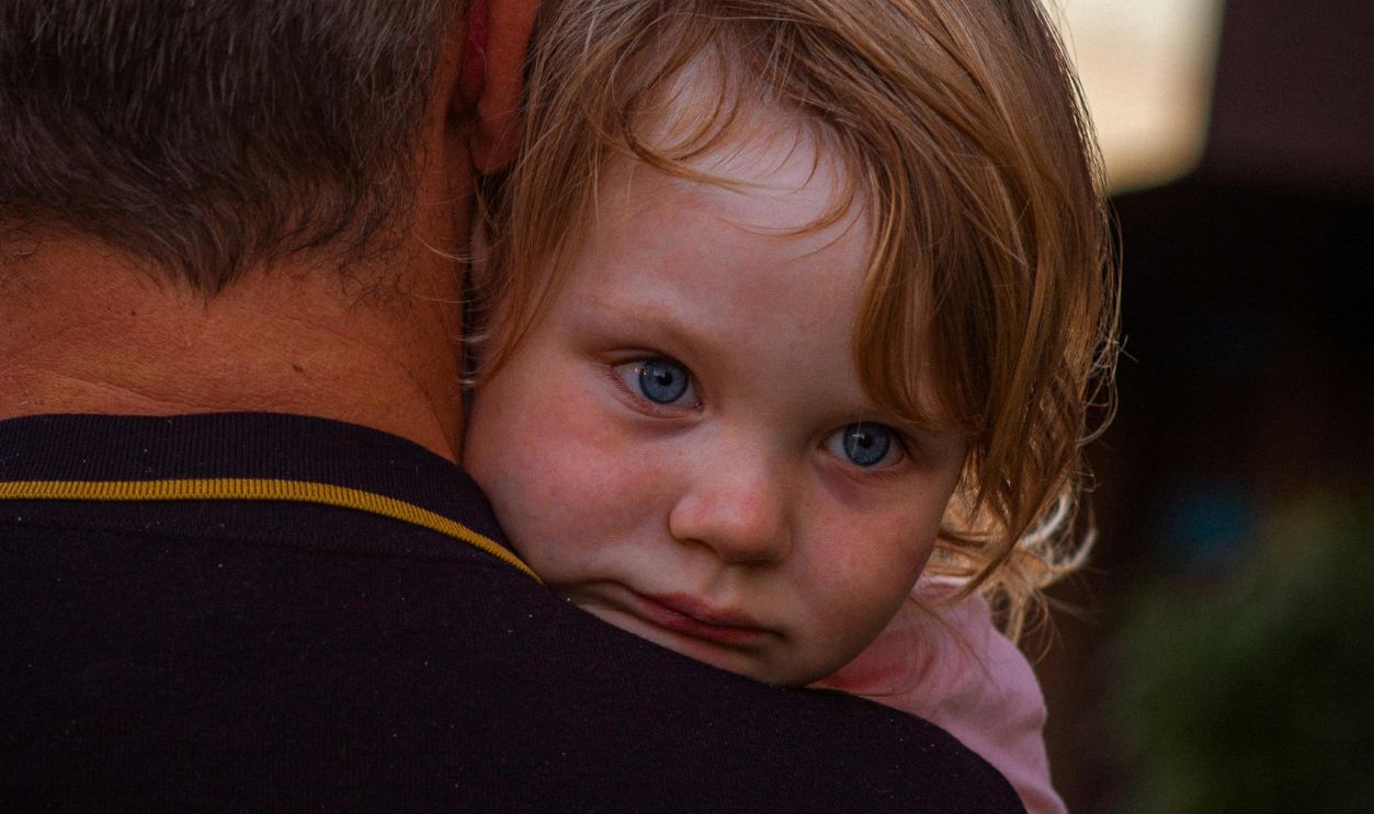A father lovingly holds his daughter, showcasing bonding and affection
