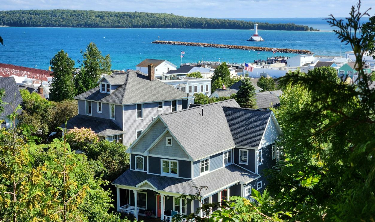 Scenic view of coastal homes by the sea with a lighthouse in the background