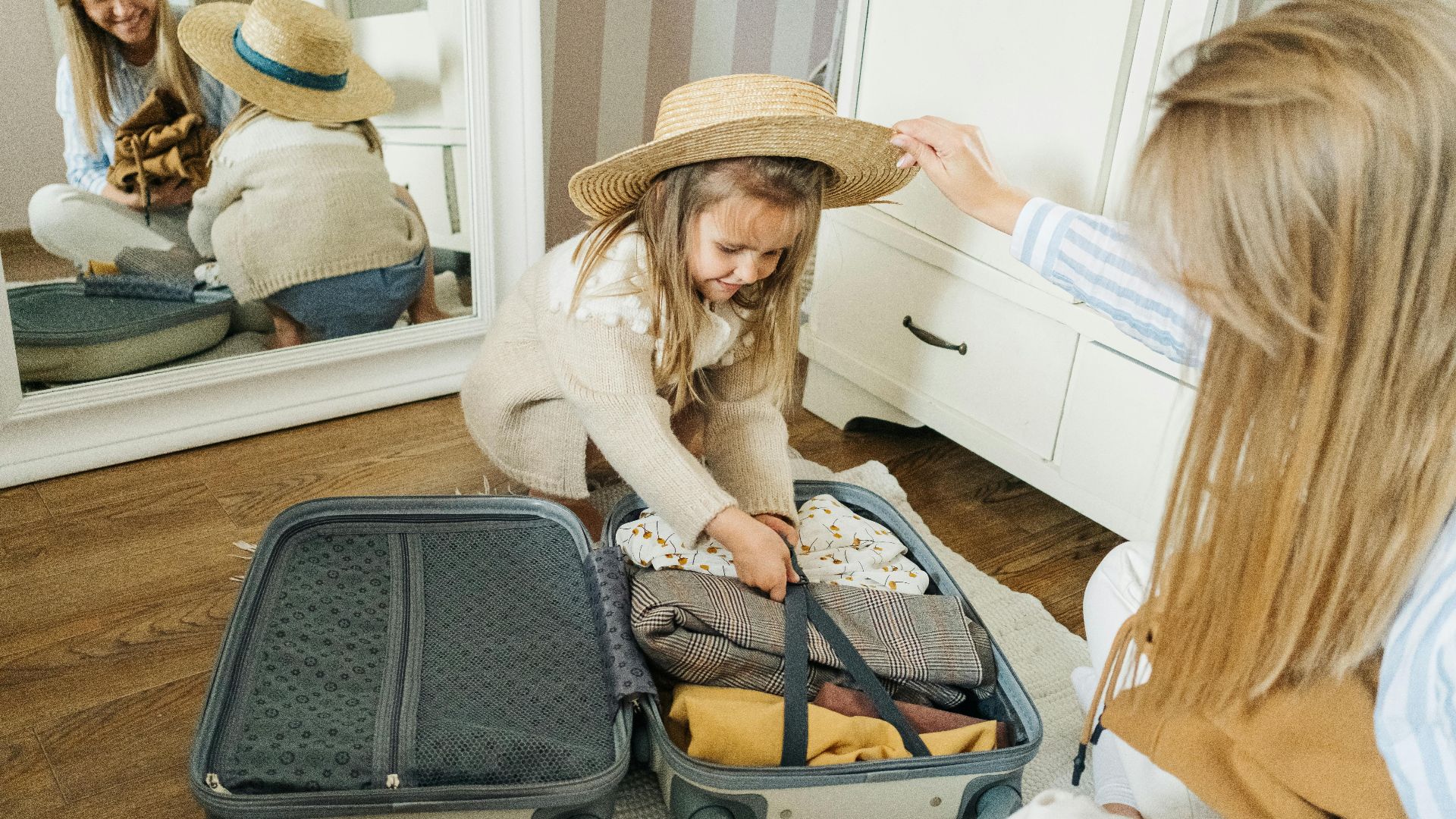 A mother and daughter pack a suitcase for a summer vacation, creating joyful memories.