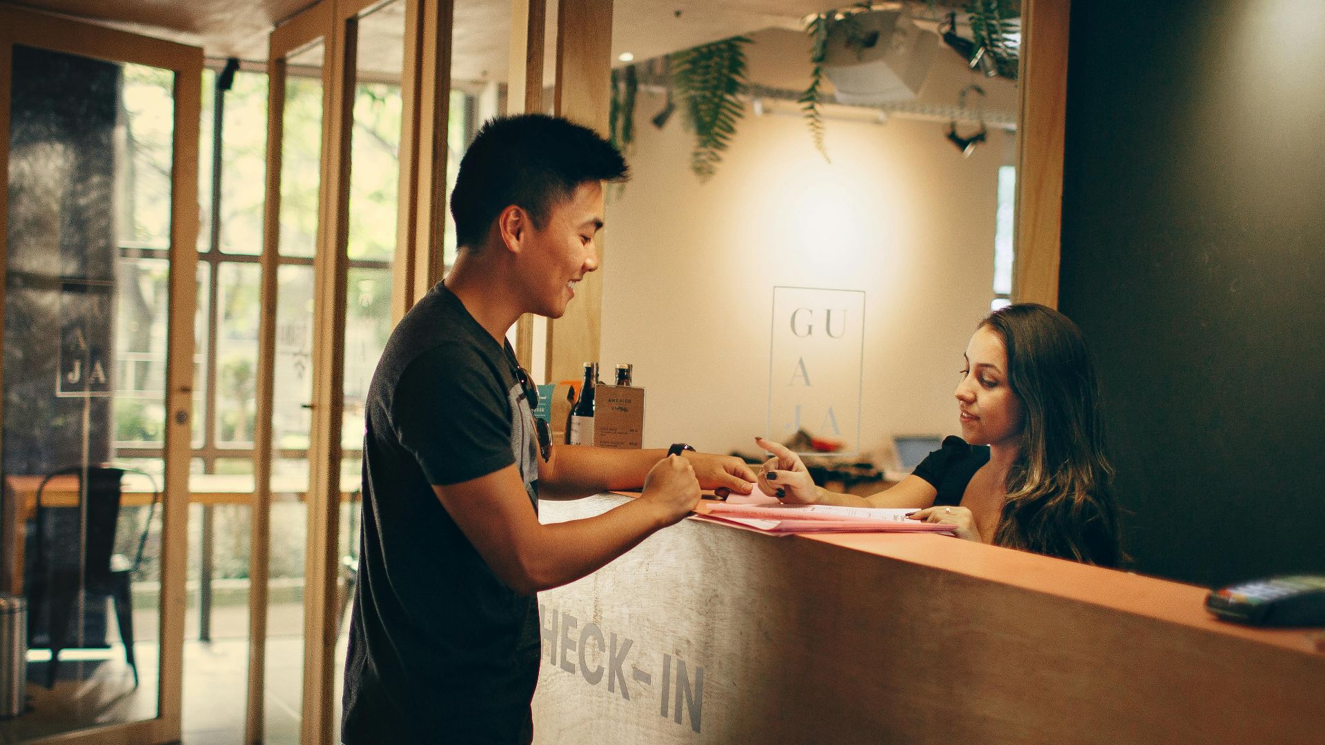 A customer checks in at a hotel reception desk in Belo Horizonte, Brazil.