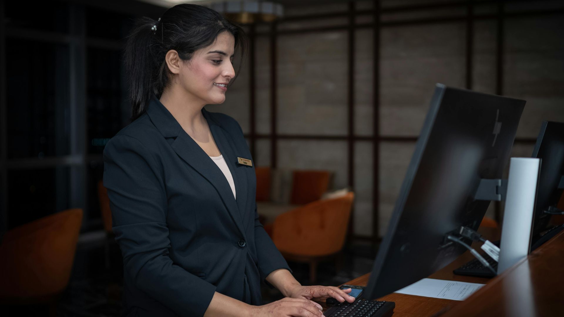 A female receptionist working at a hotel front desk in Islamabad, Pakistan.
