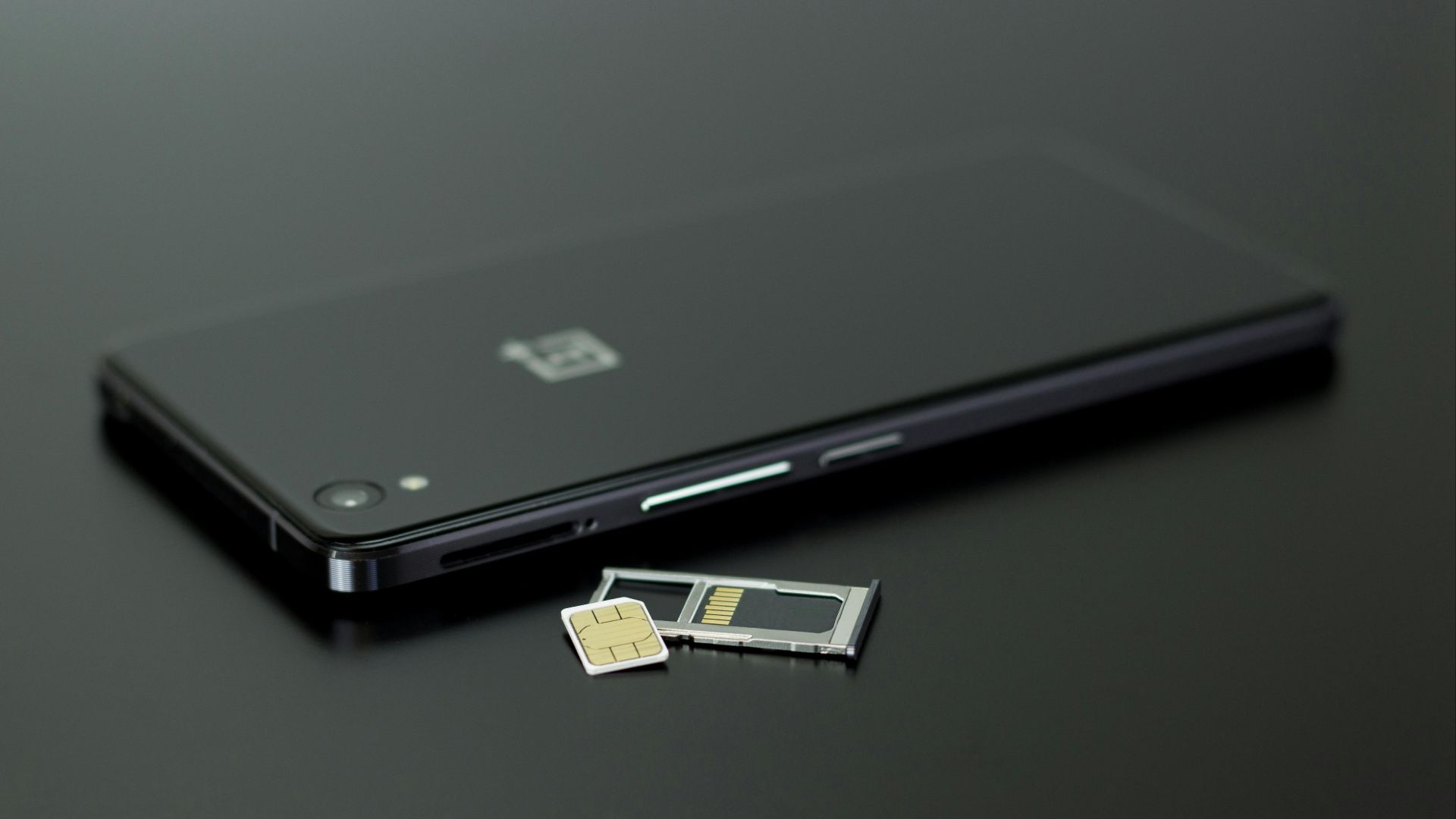 Close-up of a smartphone with a SIM card and memory card, showcasing modern technology.