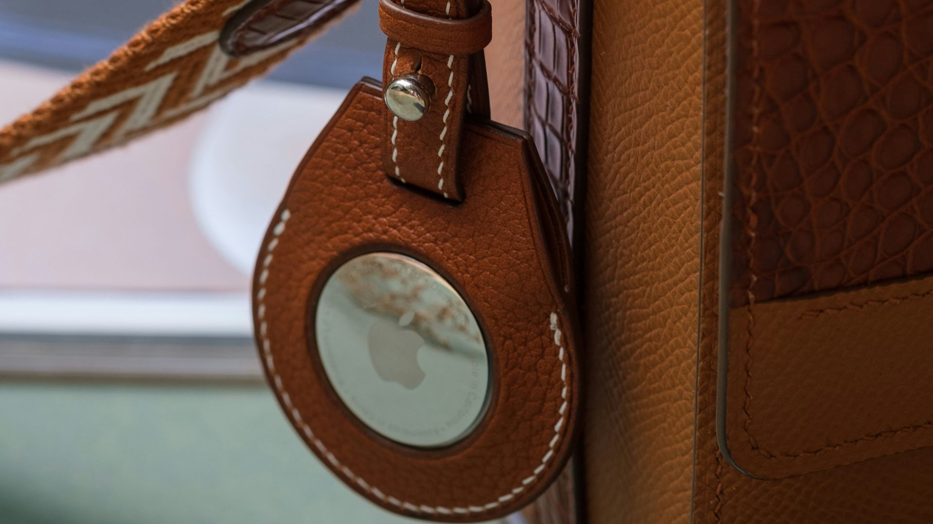 a brown purse with a key chain attached to it