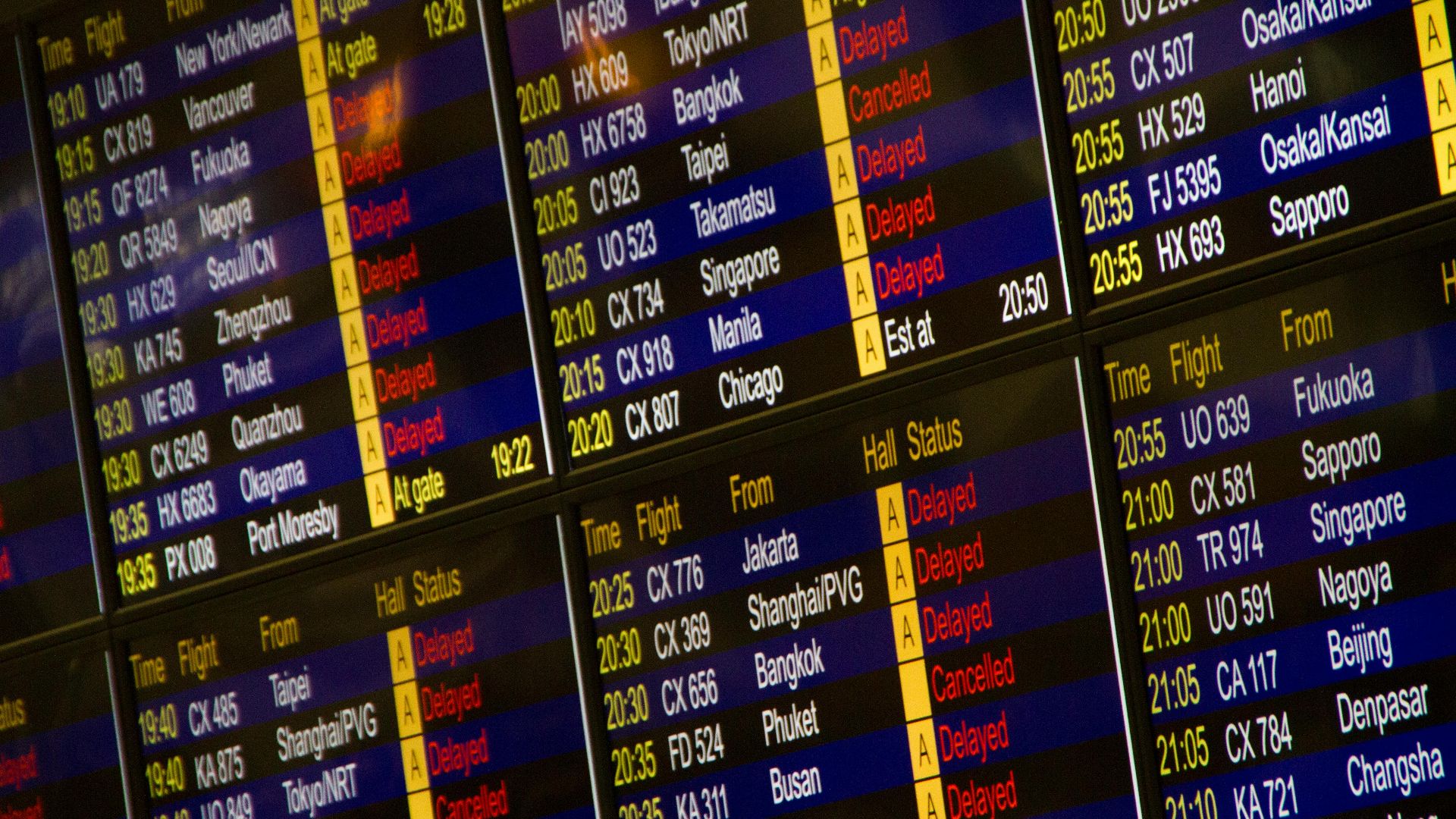 Close-up of digital flight information board showing arrivals and departures at an airport.