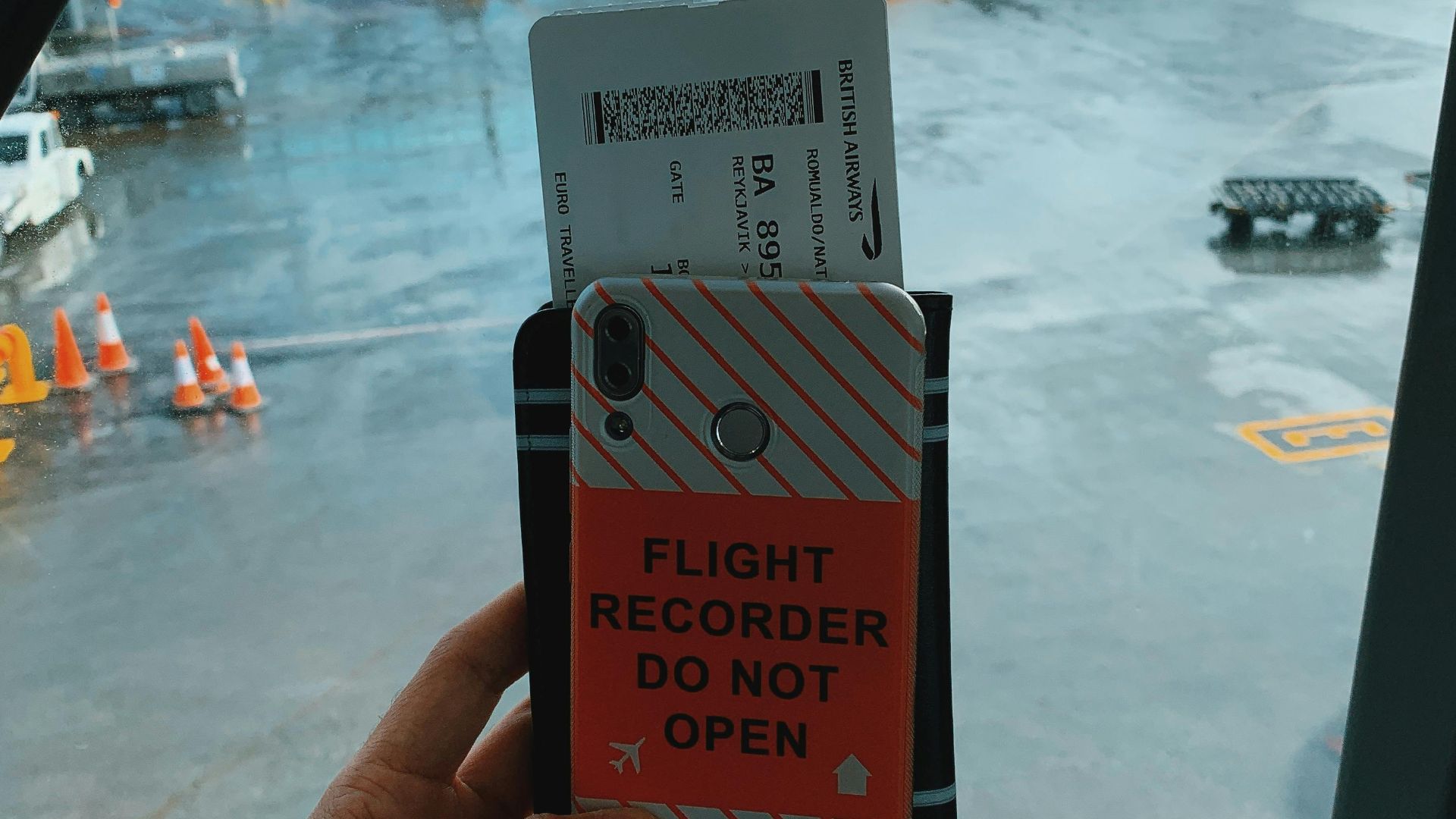 Faceless tourist holding mobile phone with sticker and boarding pass with documents against amazing view of modern airplane