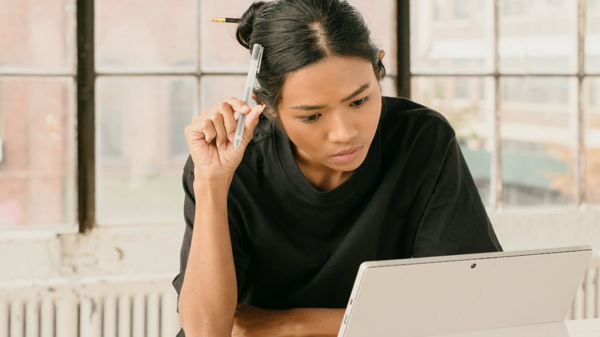 a woman sitting at a table using a laptop computer