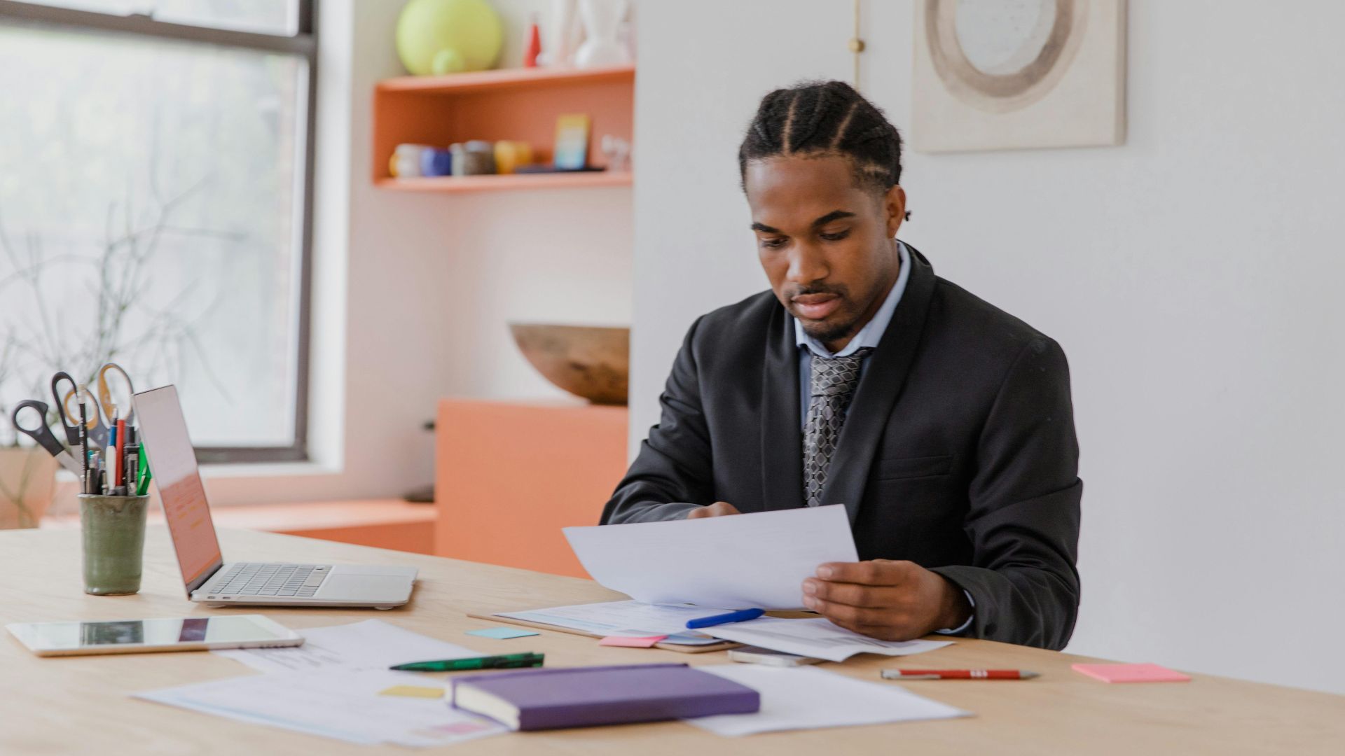 Focused businessman reviewing documents in a modern office setting.