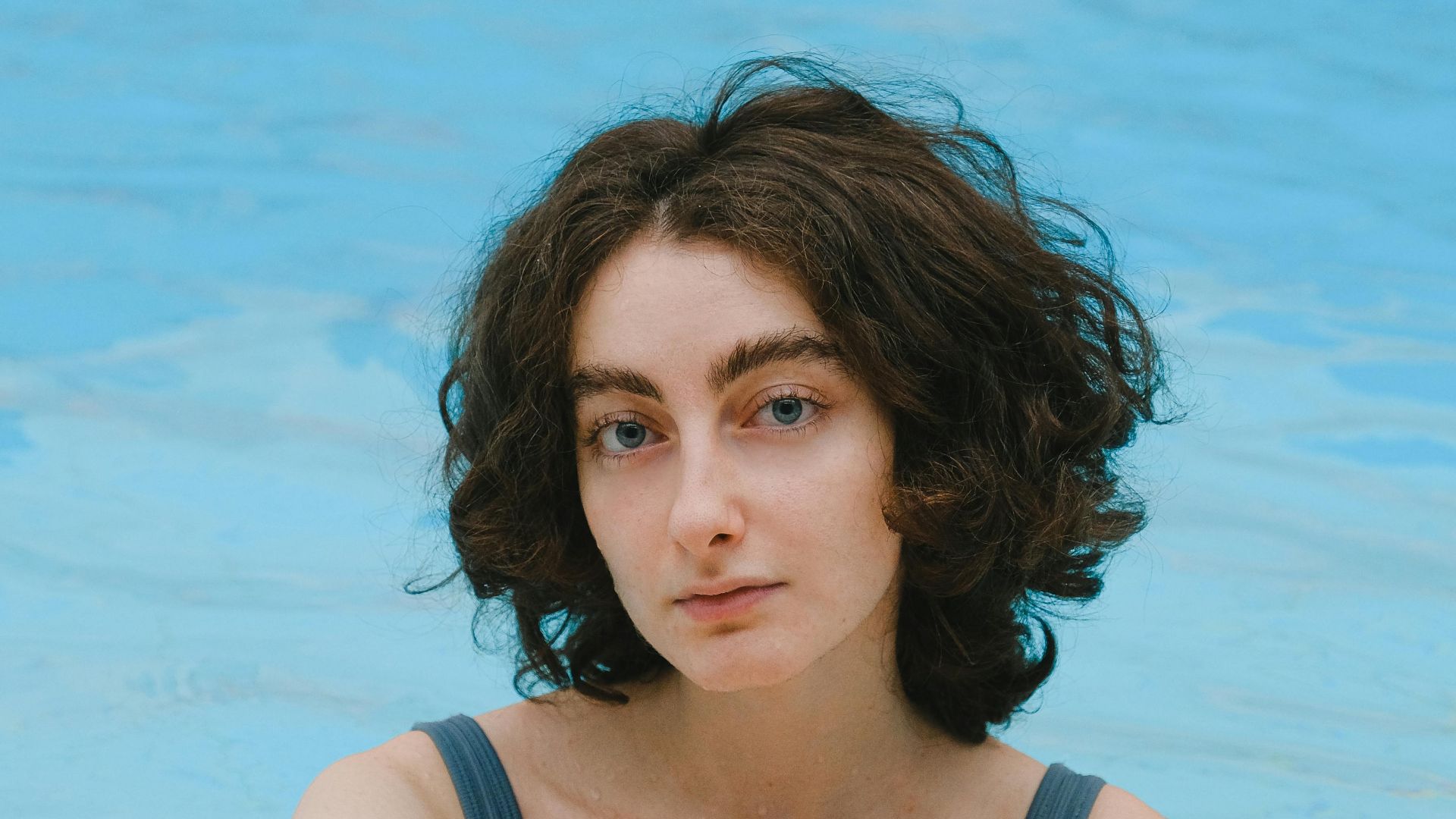 Young woman in a swimwear enjoying leisure time in a pool.