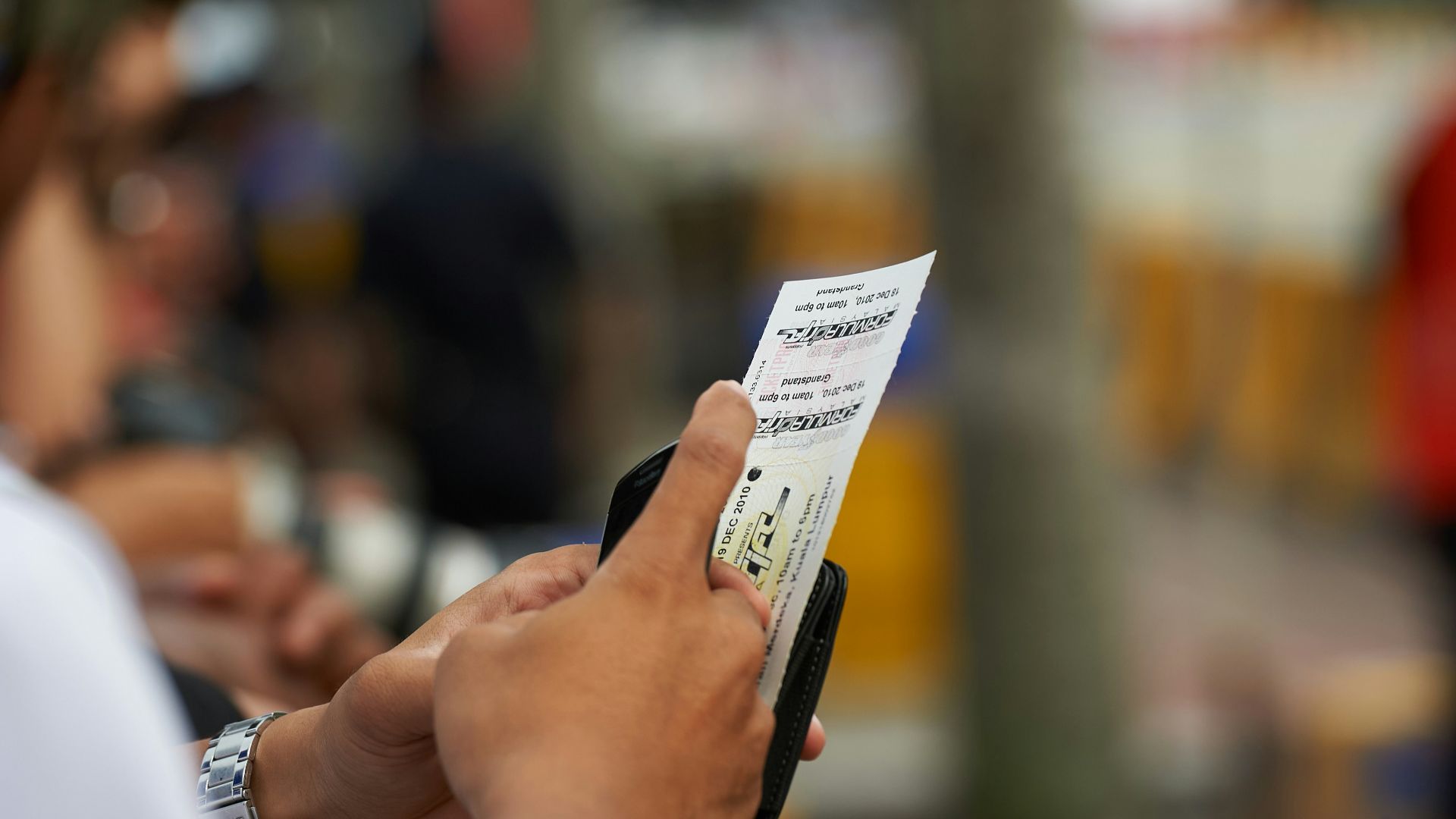 Person holding a lottery ticket with blurred background