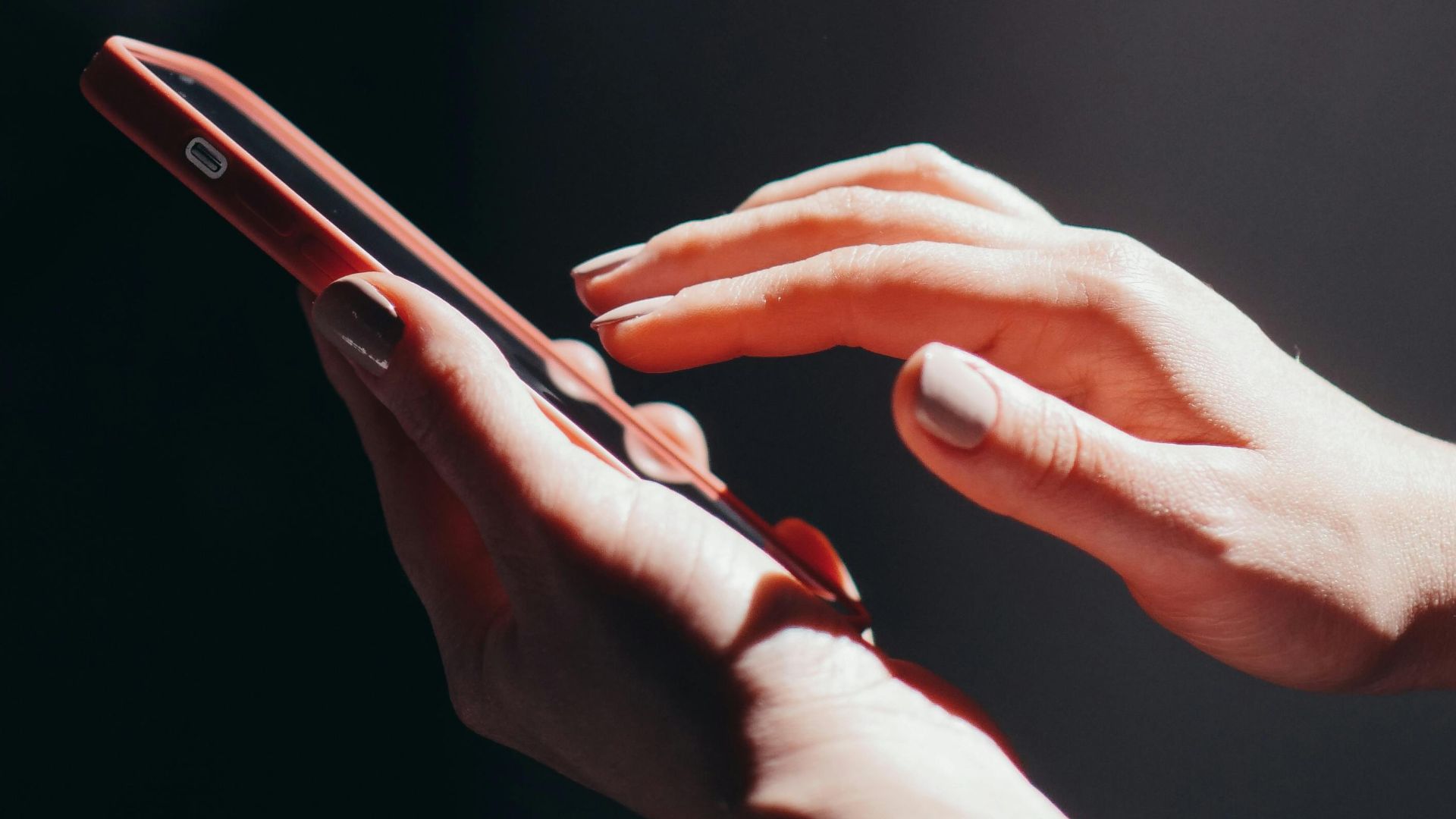 Hands interacting with a smartphone in a well-lit setting, emphasizing connection and technology.