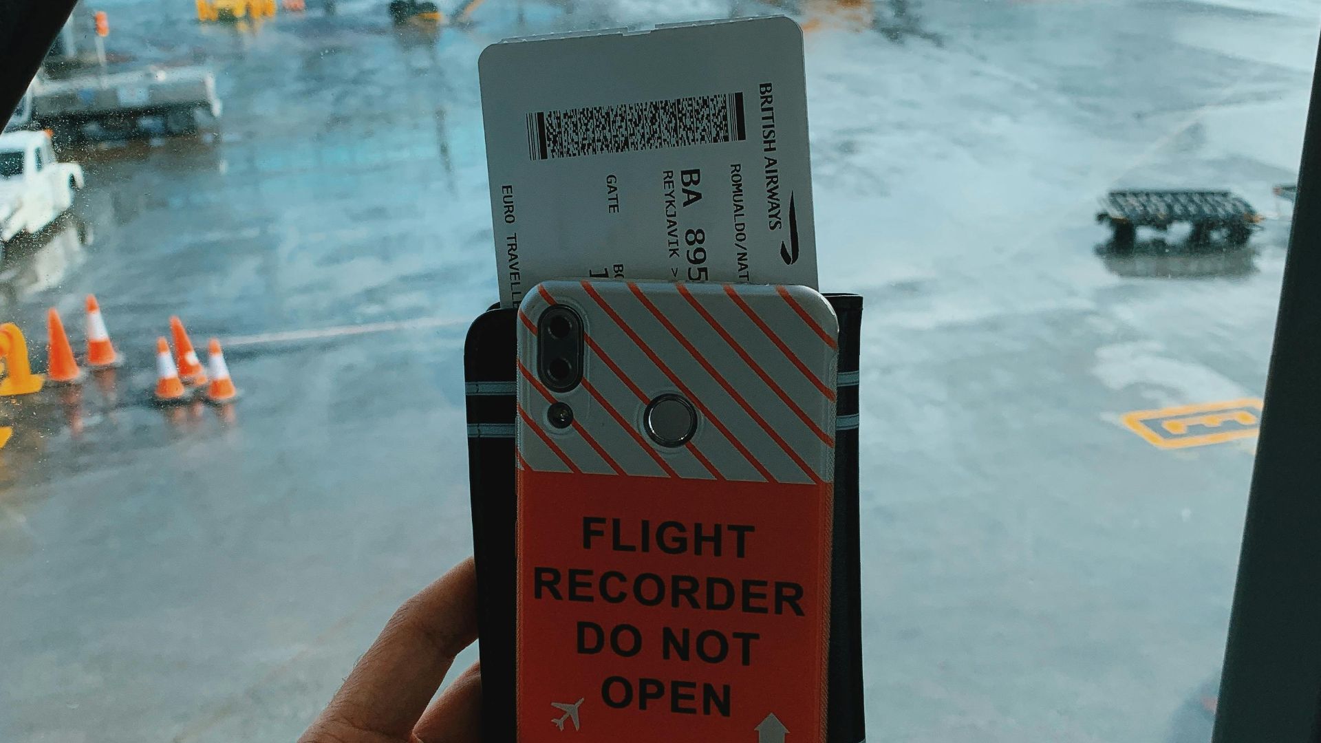 Faceless tourist holding mobile phone with sticker and boarding pass with documents against amazing view of modern airplane