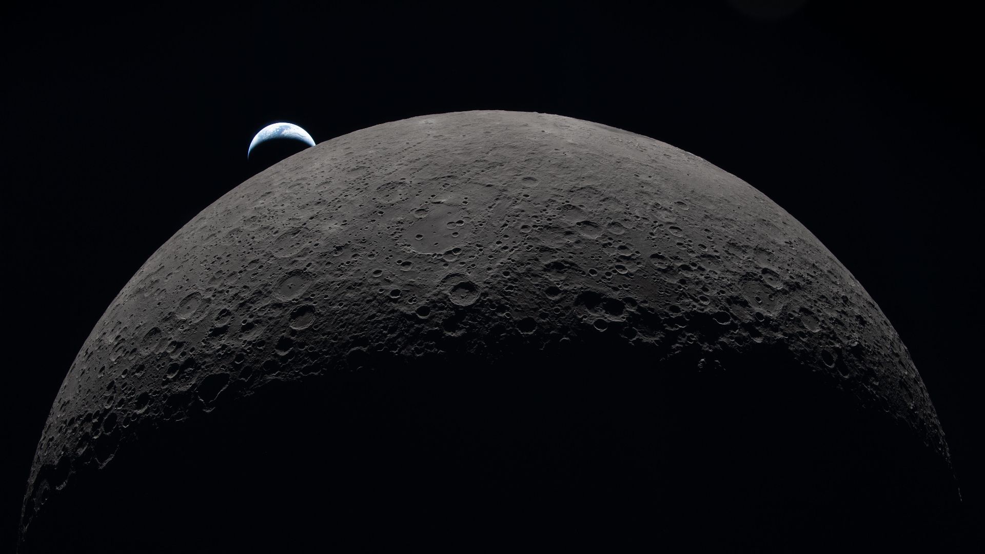 art002e009287 (April 6, 2026) – Earth sets at 6:41 p.m. EDT, April 6, 2026, over the Moon’s curved limb in this photo captured by the Artemis II crew during their journey around the far side of the Moon. Orientale basin is perched on the edge of the visib