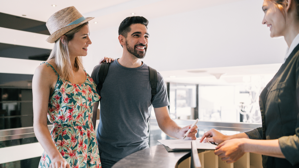 couple doing check-in at hotel reception front desk