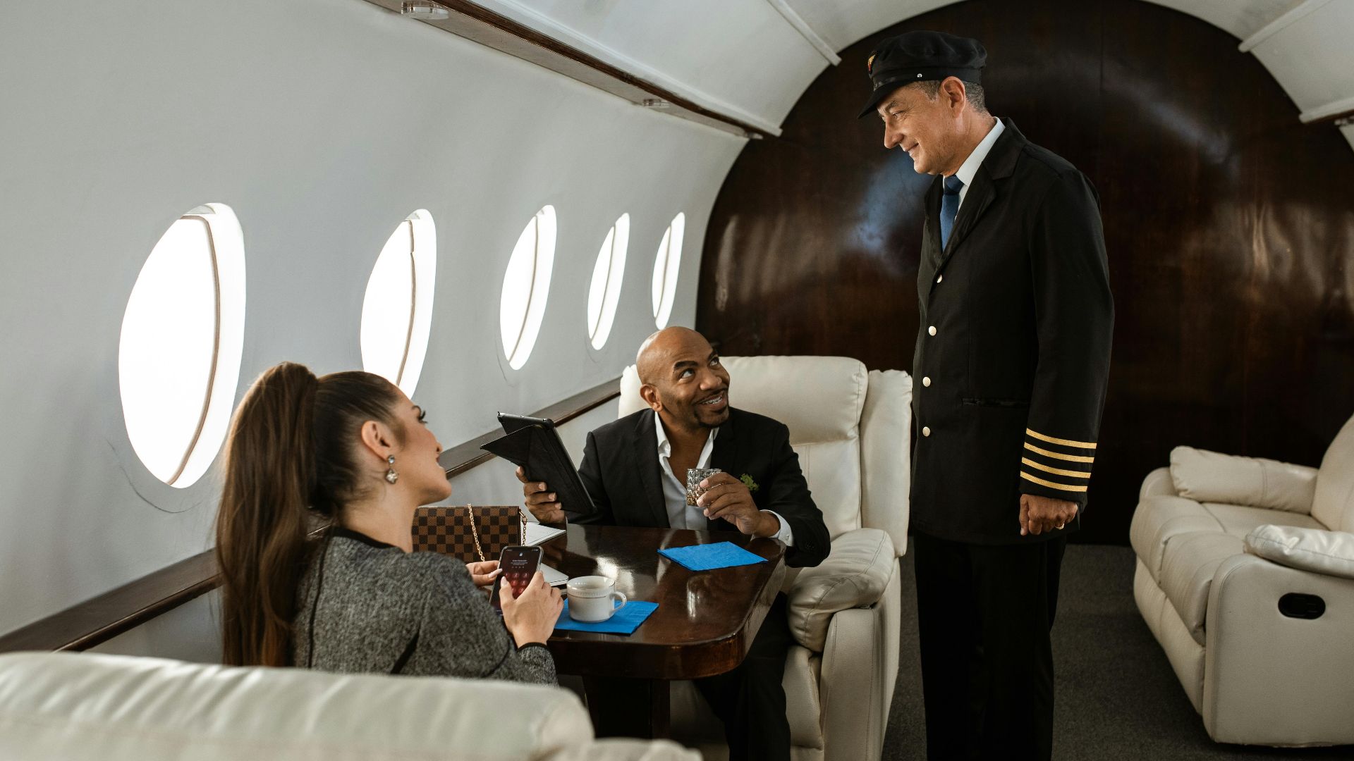 Professionals engaging in conversation with the pilot on a private jet.