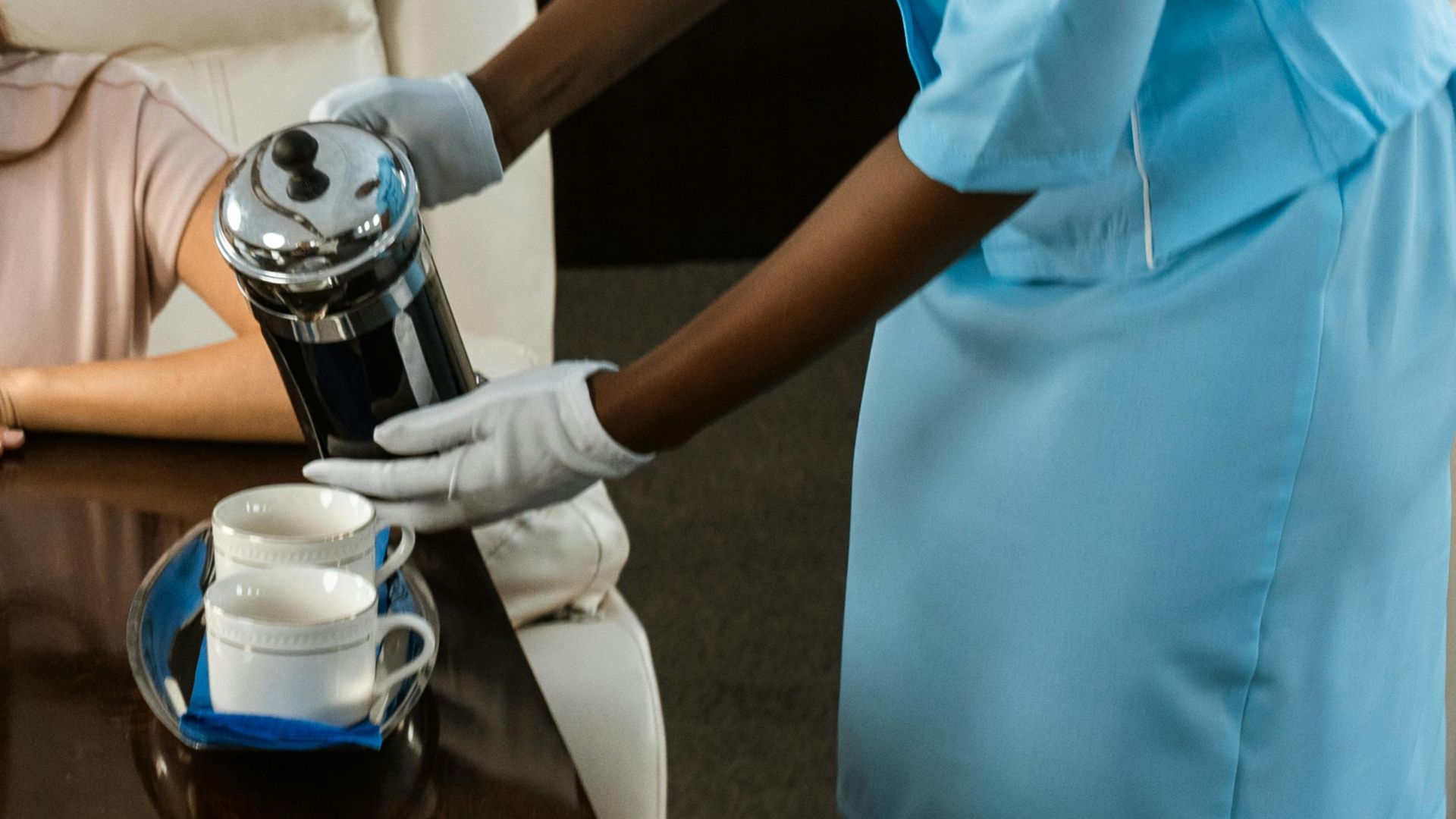 Flight attendant serving passengers in luxurious private jet cabin.