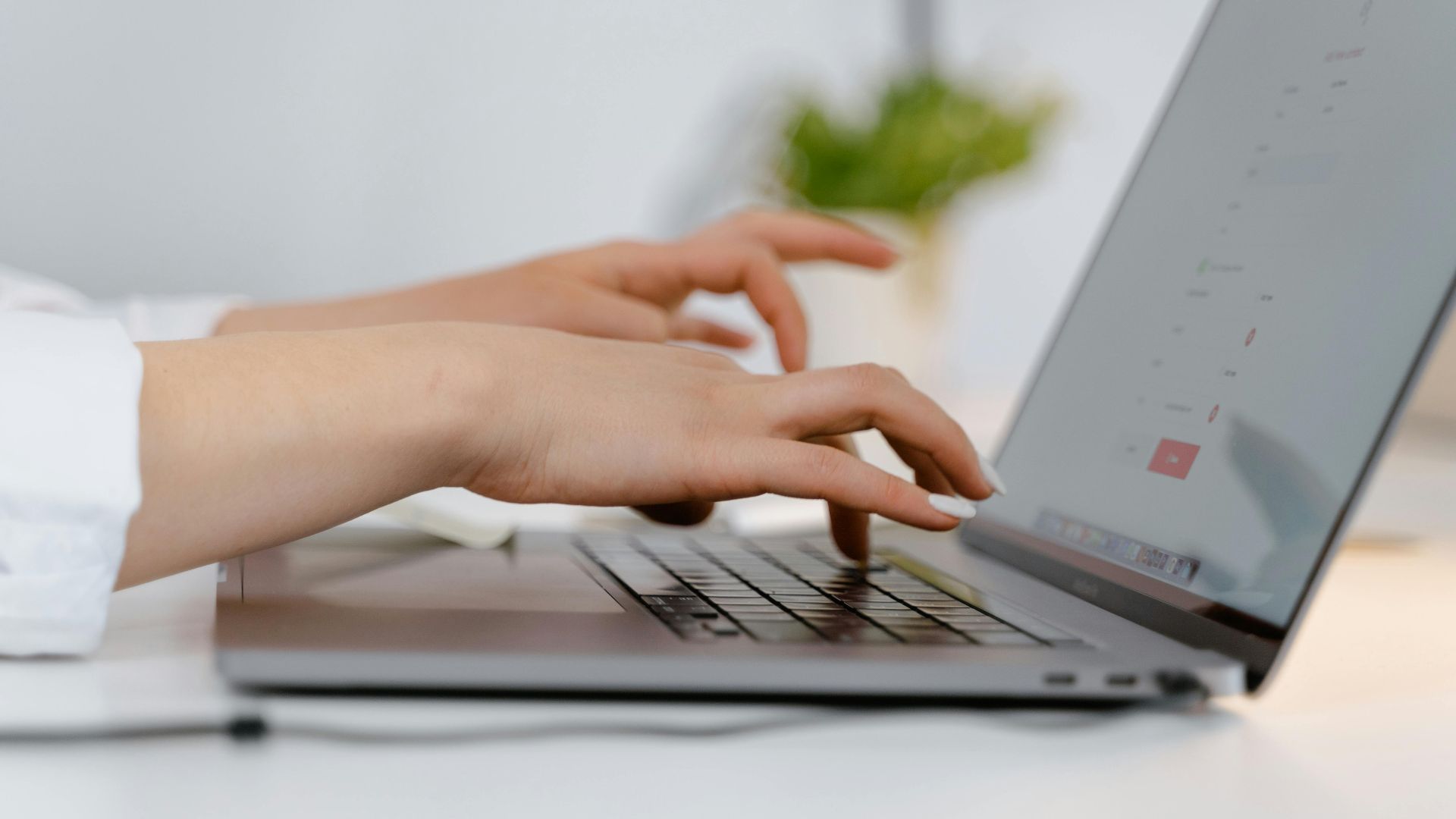 Hands typing on a laptop keyboard, ideal for concepts of remote work and technology.