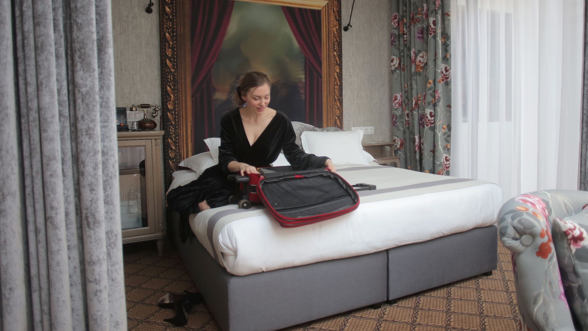 A woman in a chic hotel room packing her suitcase, ready for travel.