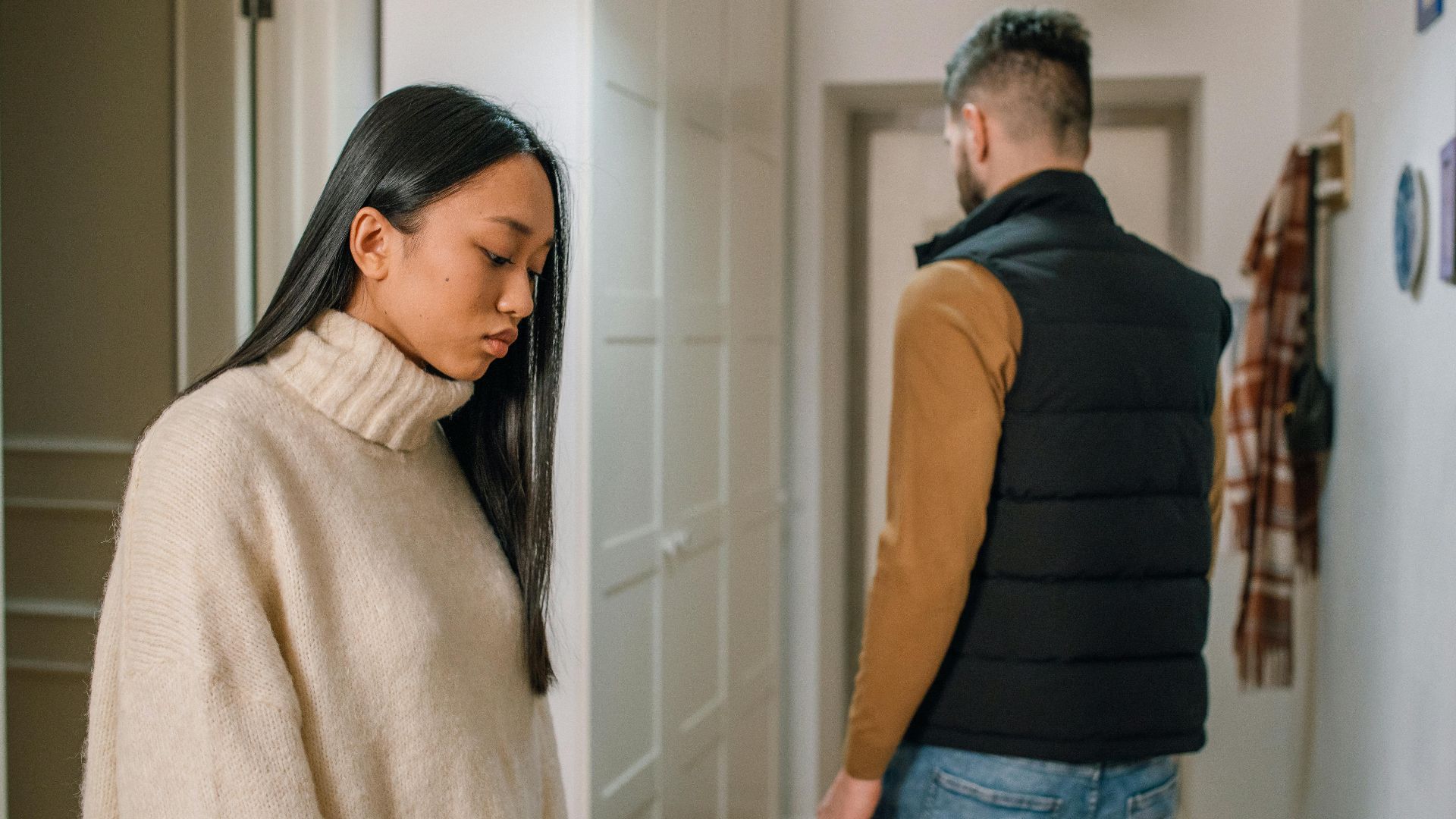 A couple experiencing relationship issues in a hallway, conveying emotional tension.