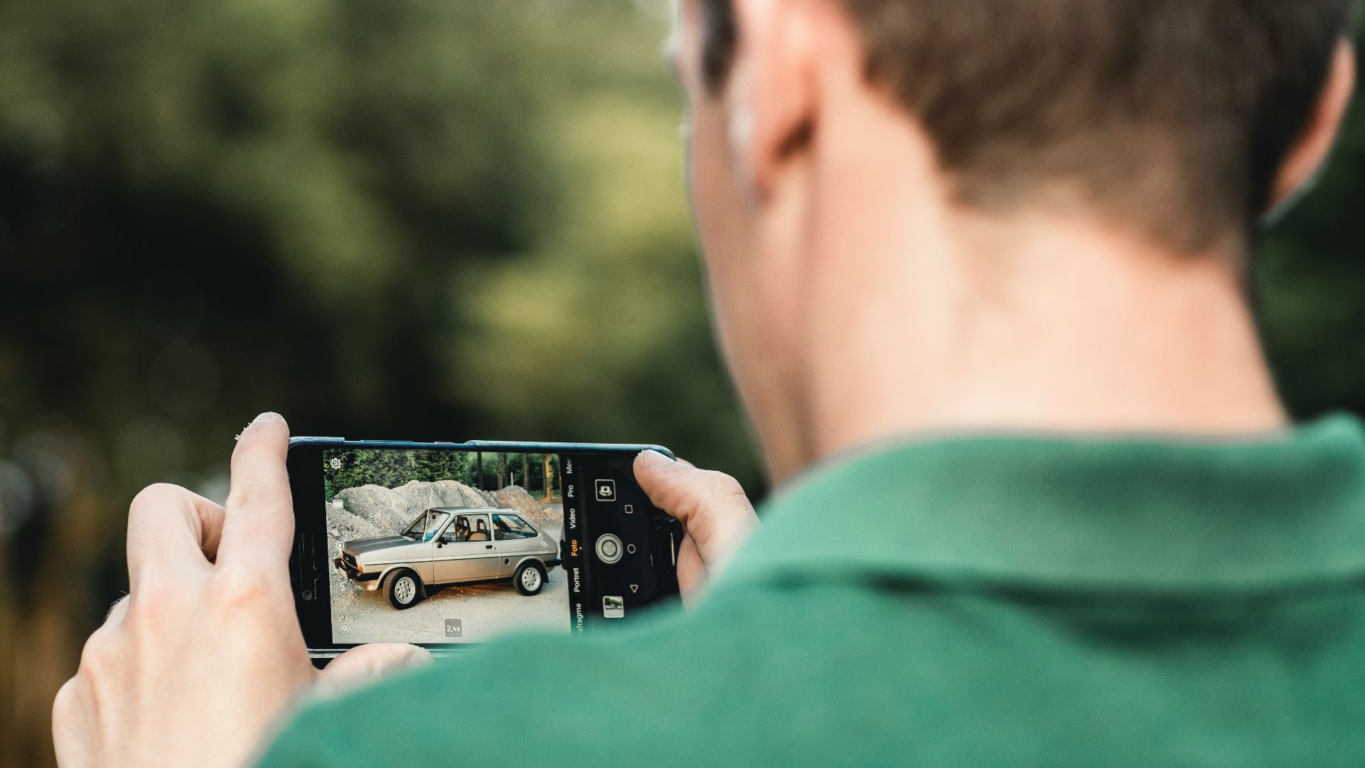 man taking photo of car