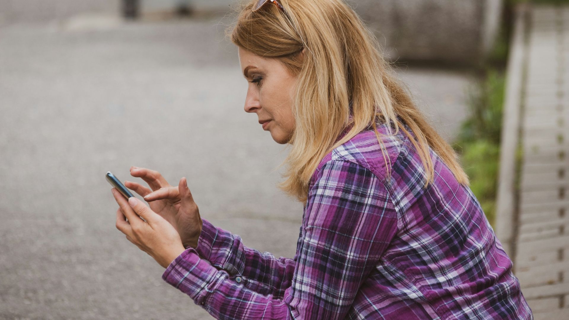 a woman sitting on the ground looking at her cell phone