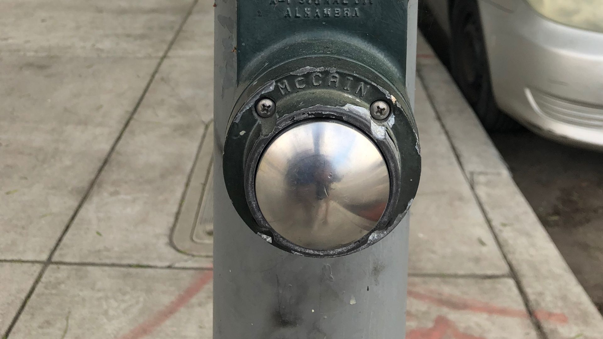 The pedestrian call button to cross North 7th Street at eastbound East Taylor Street in San Jose, California.