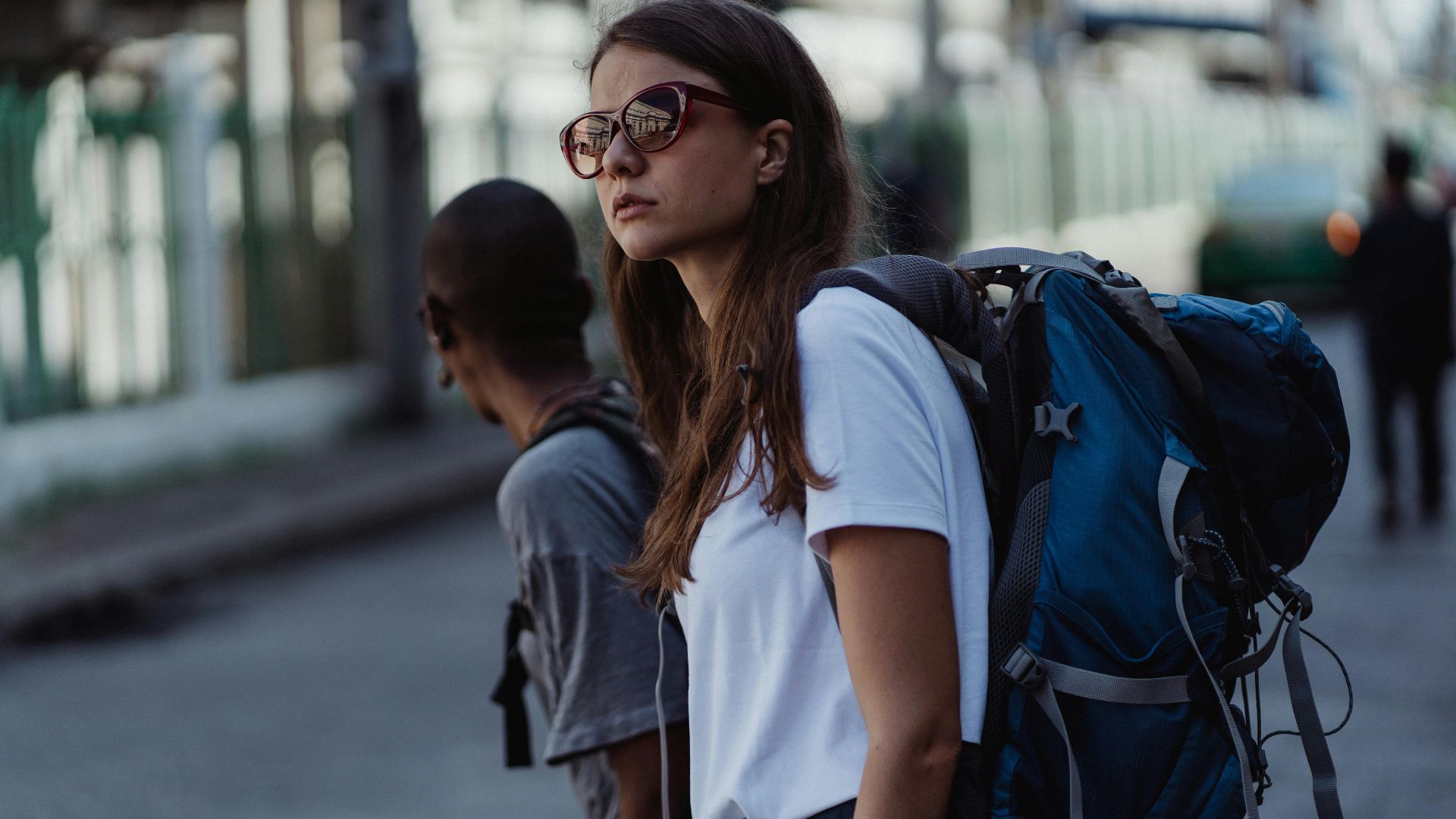 A young woman with a backpack explores the city, embracing urban travel and adventure.