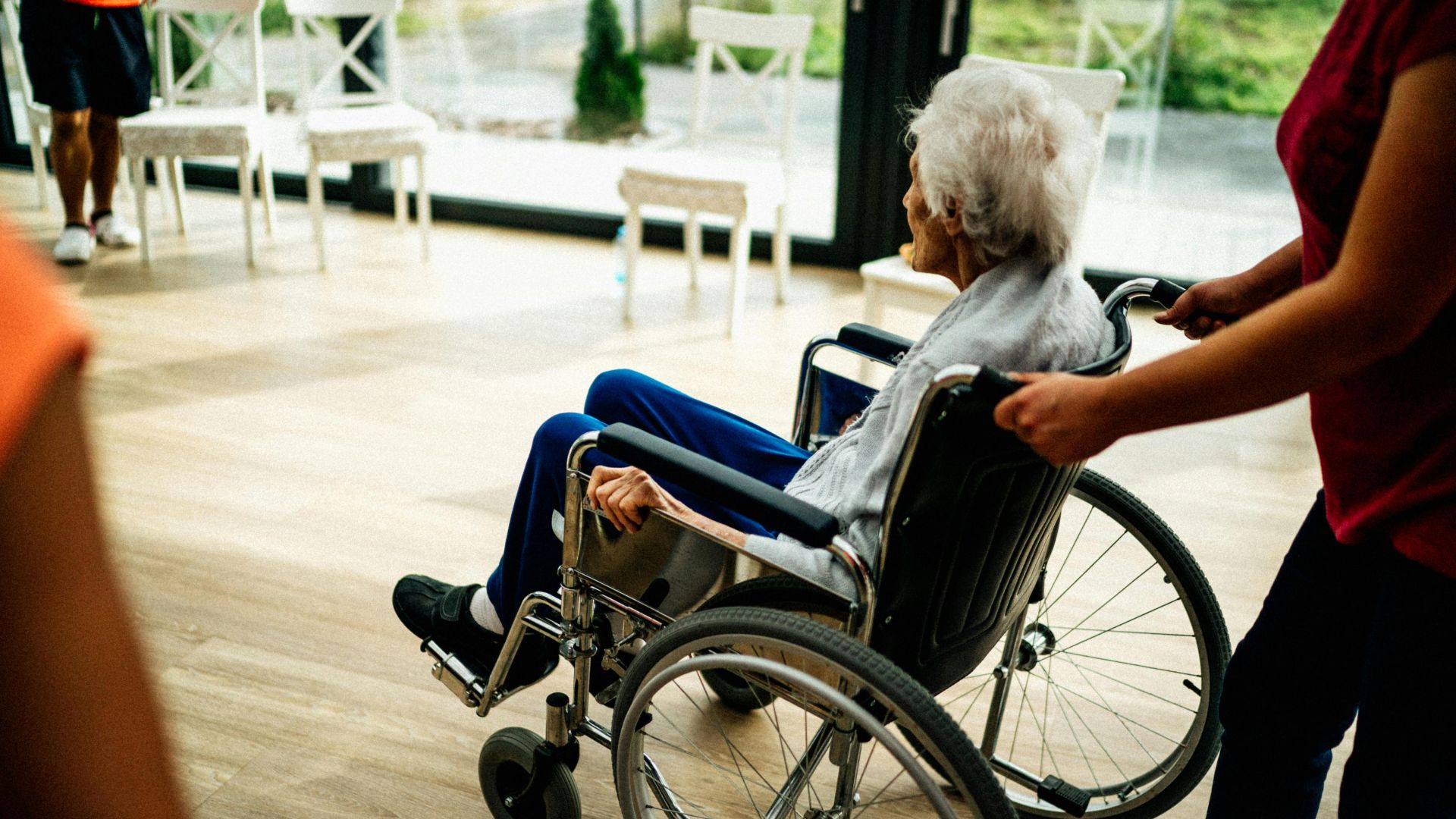 A caregiver assists a senior adult in a wheelchair at a nursing home in Prague, Czech Republic.