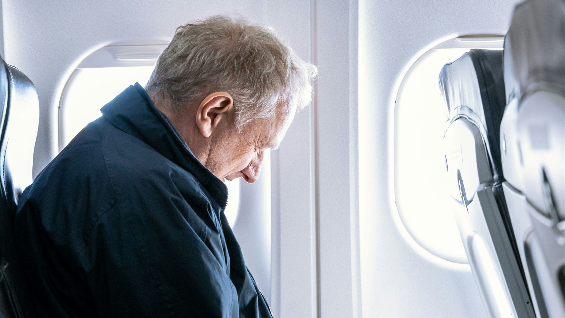 a man reading a book on an airplane