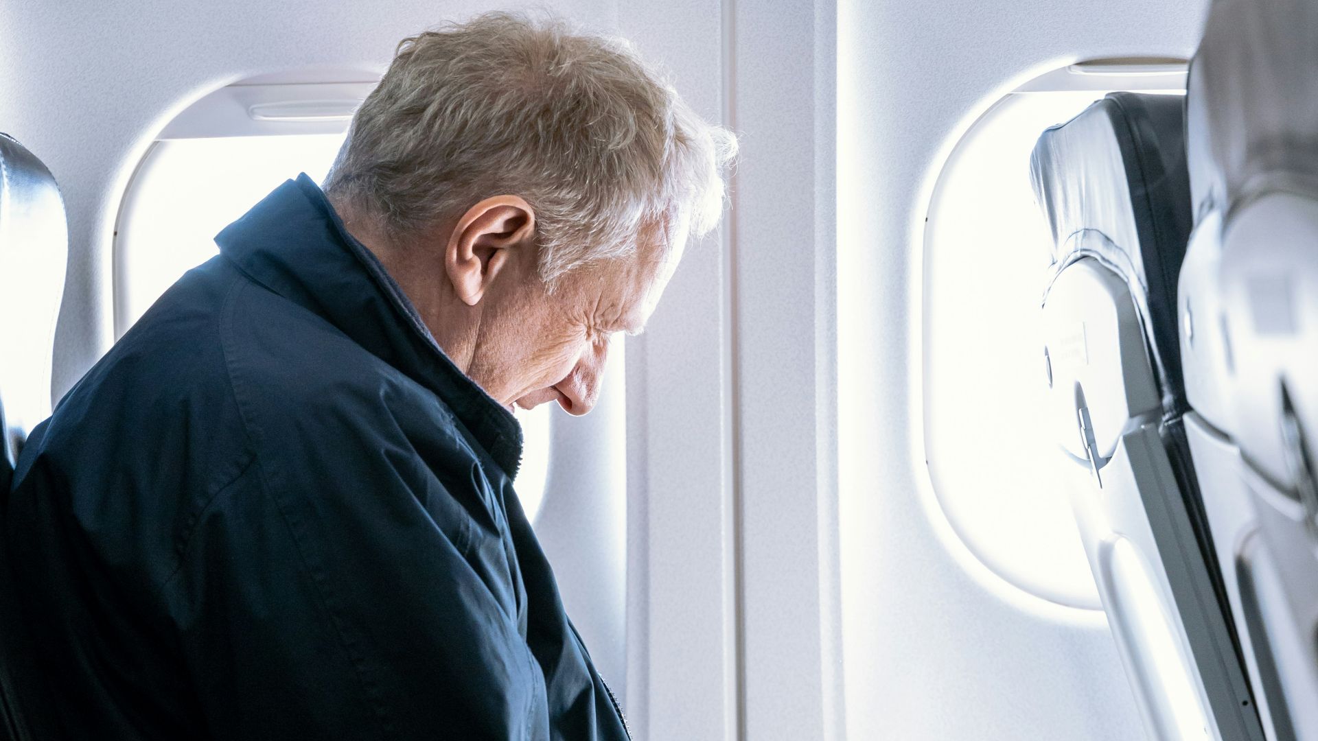 a man reading a book on an airplane