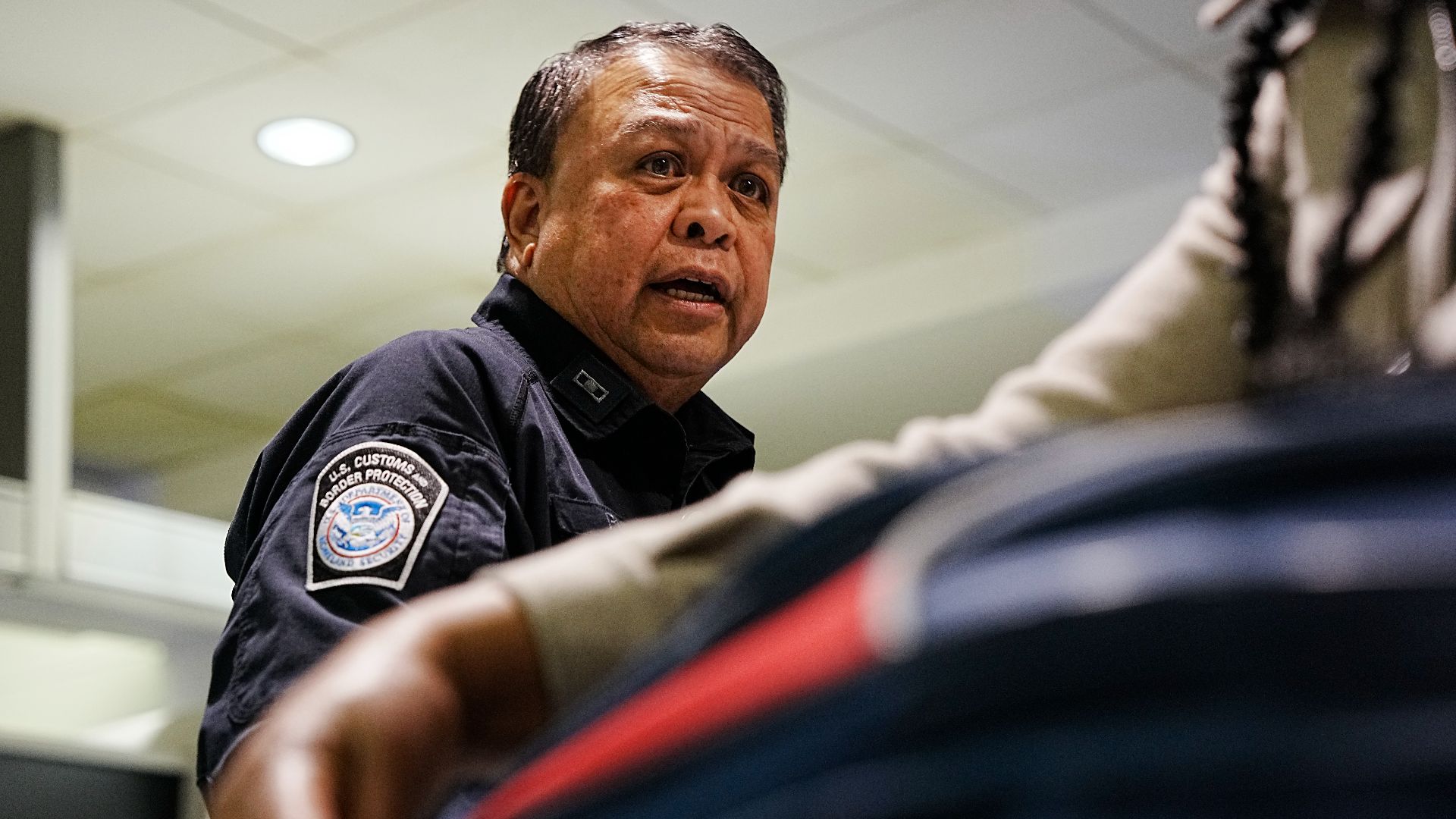 A U.S. Customs and Border Protection Office of Field Operations agriculture specialist searches the luggage of international travelers arriving at Baltimore/Washington International Thurgood Marshall Airport February 27, 2025. CBP Photo by Glenn Fawcett