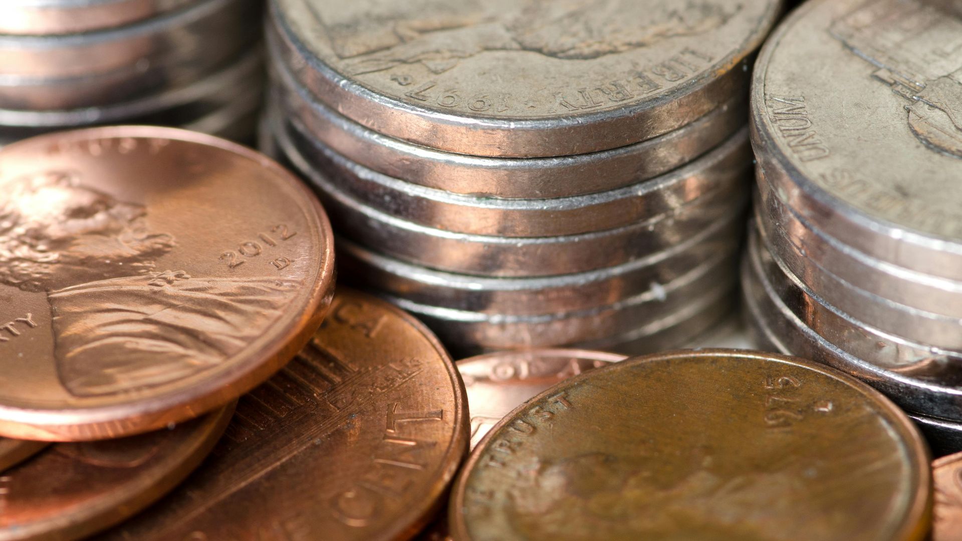 Detailed image of stacked American coins including pennies and nickels, representing savings and finance.