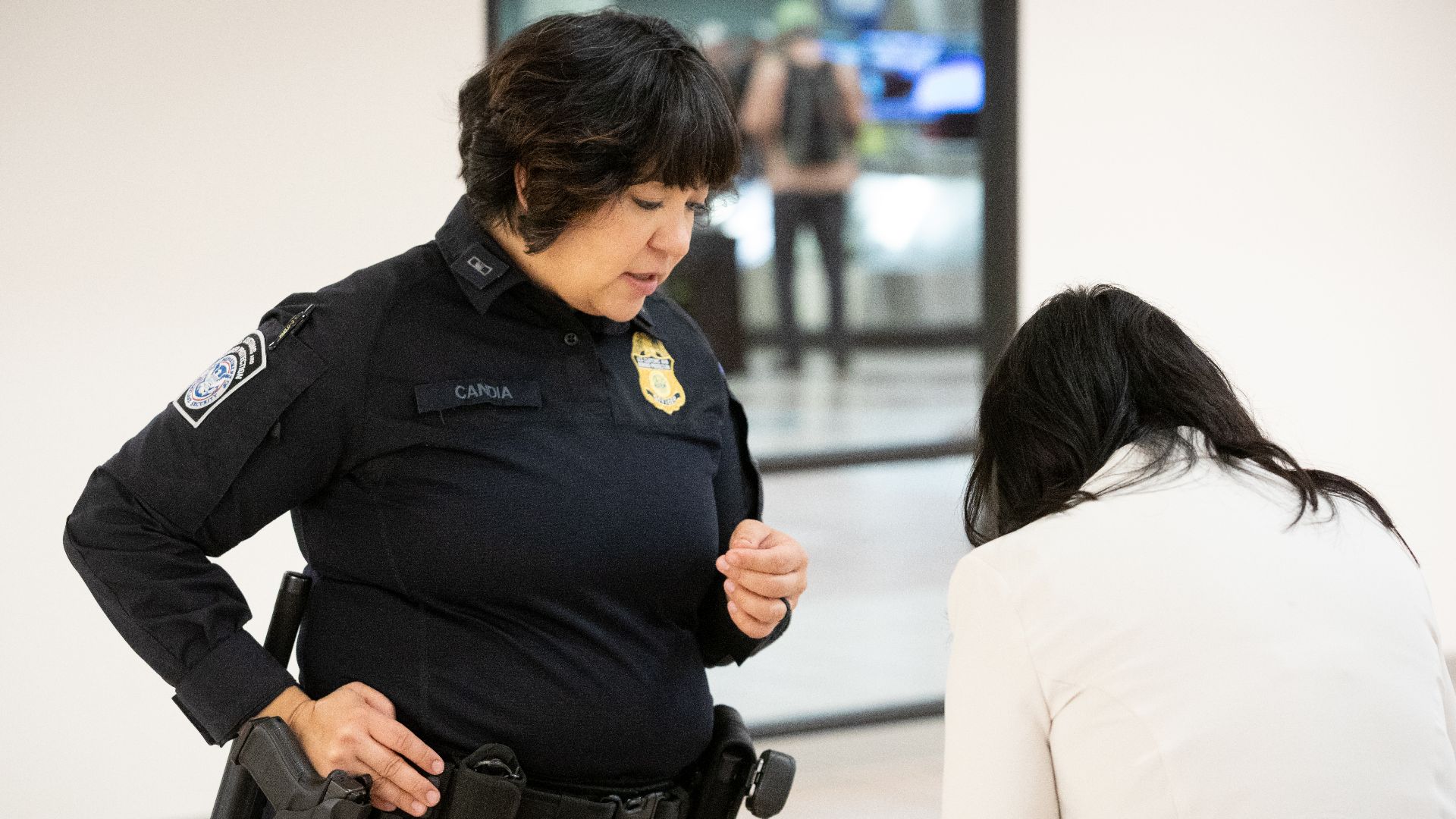 A U.S. Customs and Border Protection officer asks questions of an arriving international passenger in the baggage claim area at Phoenix Sky Harbor International Airport in Phoenix, Ariz., December 11, 2024. CBP Photo by Jerry Glaser