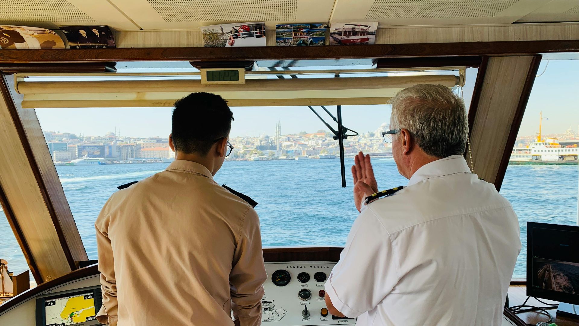 Ship captain and crew member discussing navigation on the Bosphorus in Istanbul.