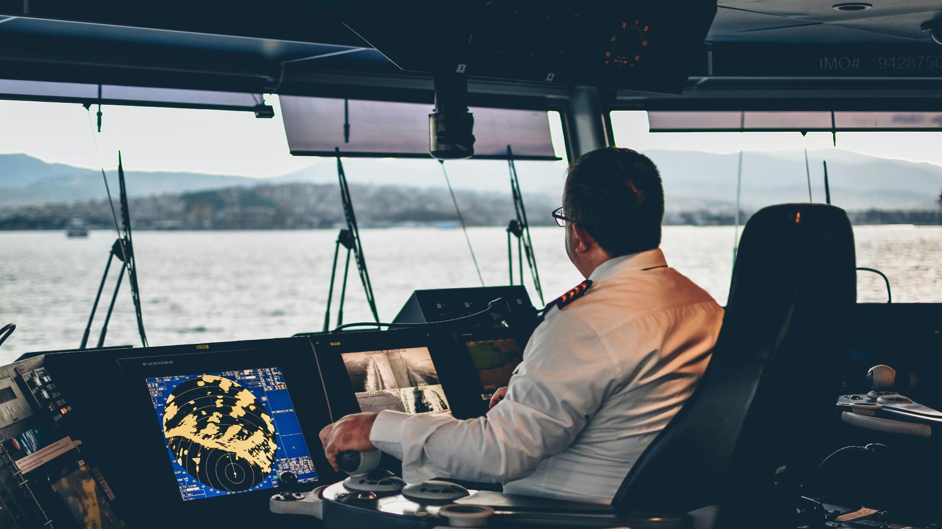 Ship captain operates navigation systems overlooking Istanbul waters. Maritime expertise at its finest.