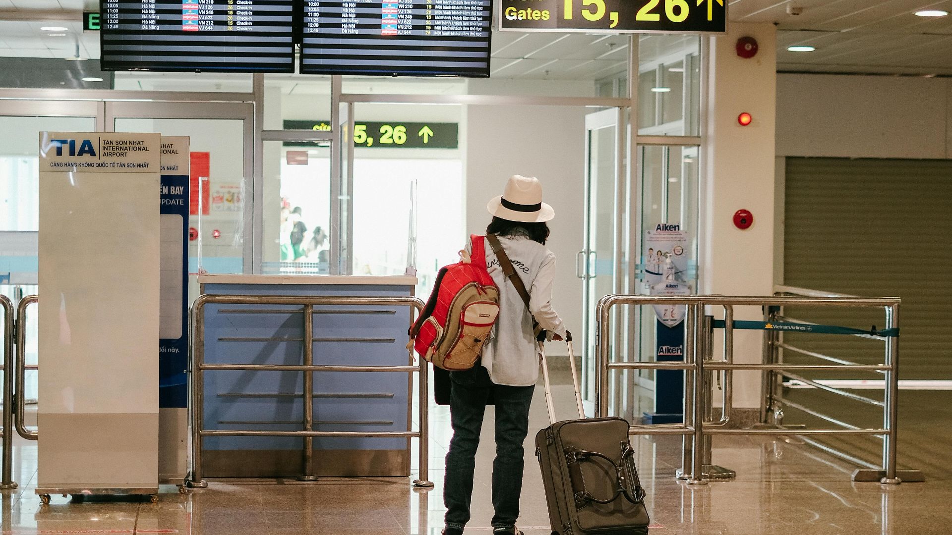 Woman with luggage exploring airport terminal. Solo travel and future adventures.