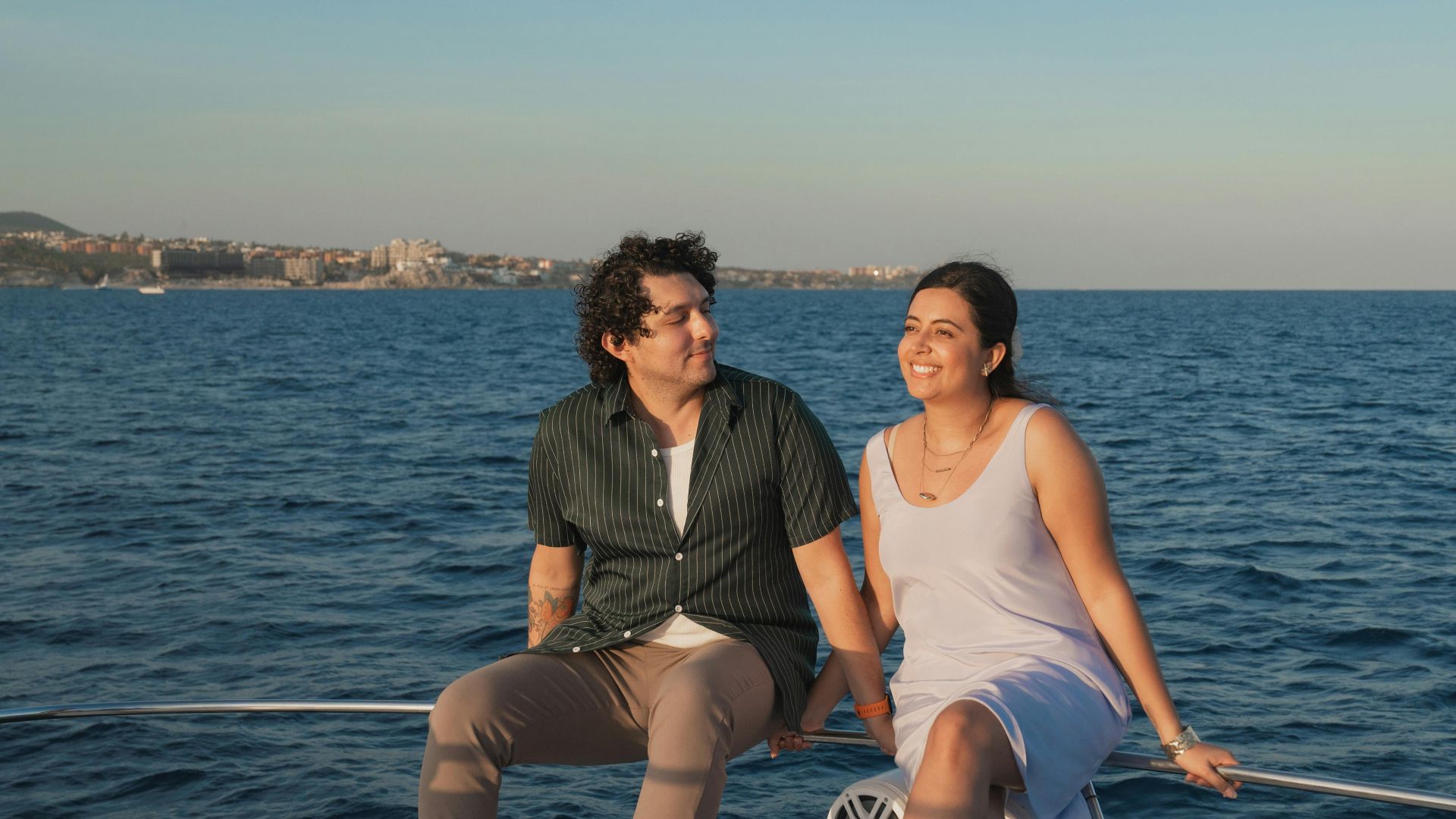 A happy couple enjoying a relaxing boat ride at sunset on a calm sea.