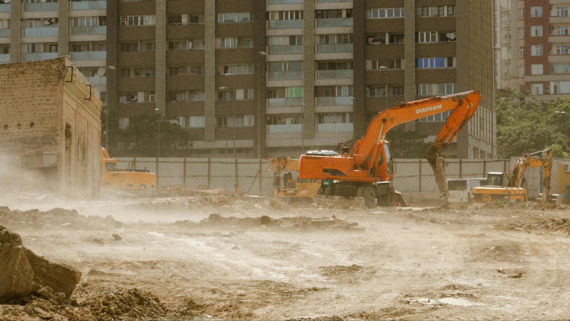 A construction site with excavators and apartment buildings in Baku, Azerbaijan.