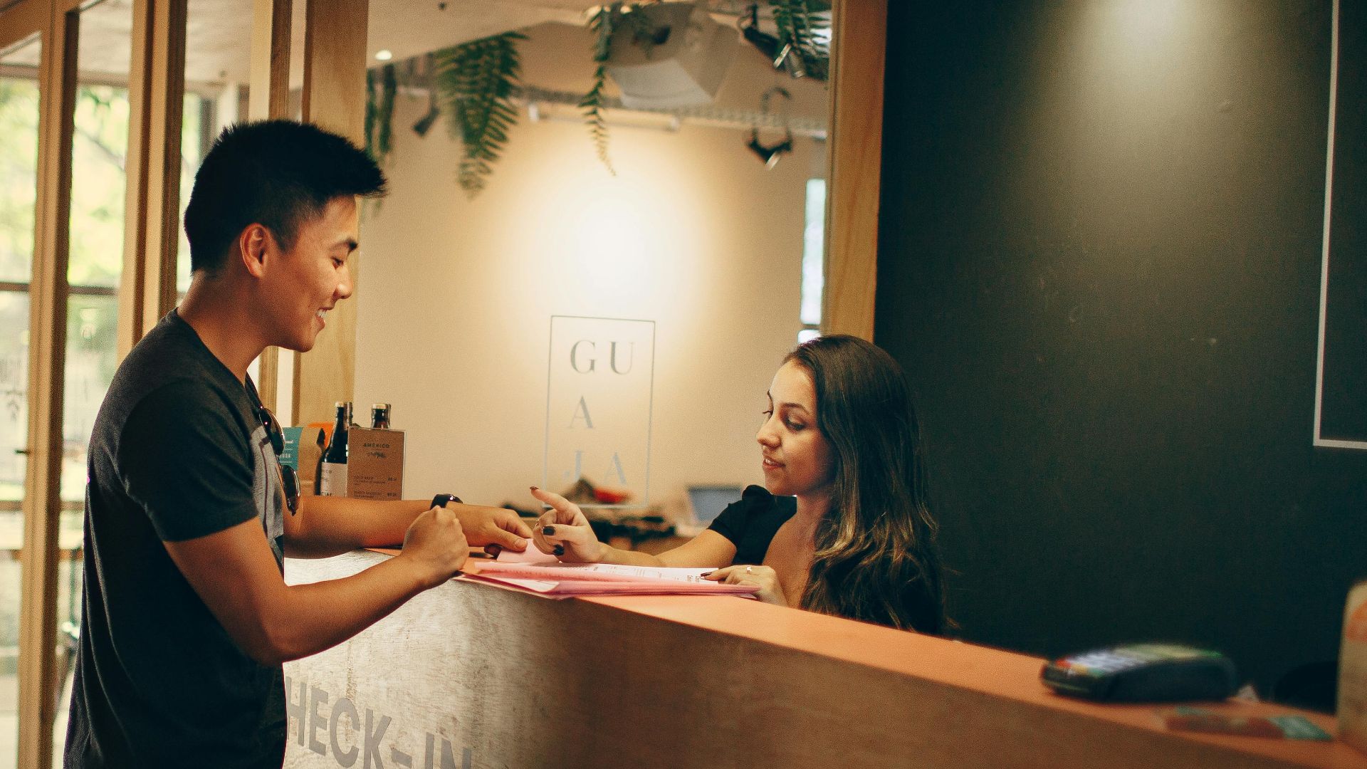 A customer checks in at a hotel reception desk in Belo Horizonte, Brazil.