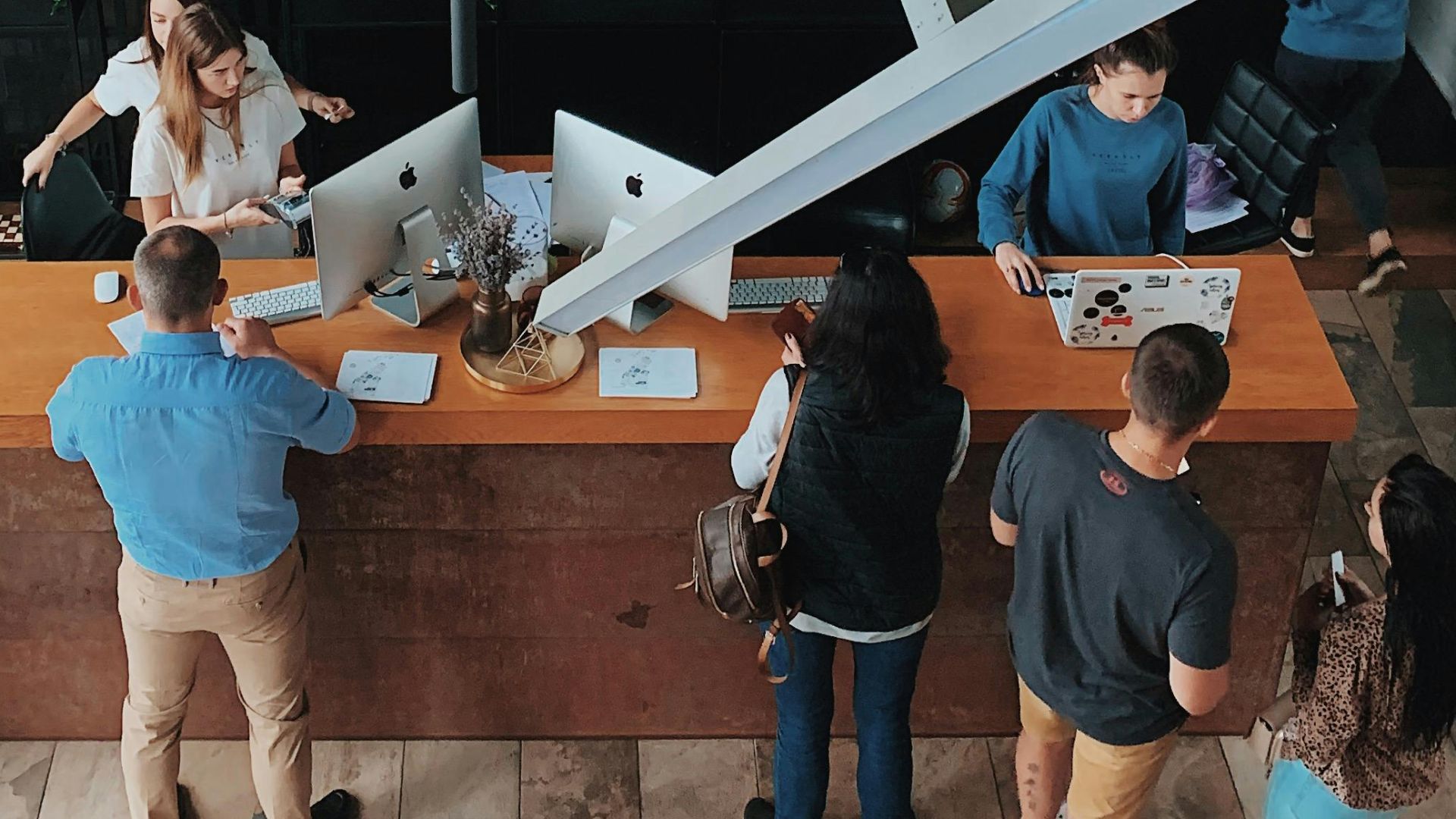 Aerial view of a modern hotel reception with people interacting at the desk in Sosnivka, Ukraine.