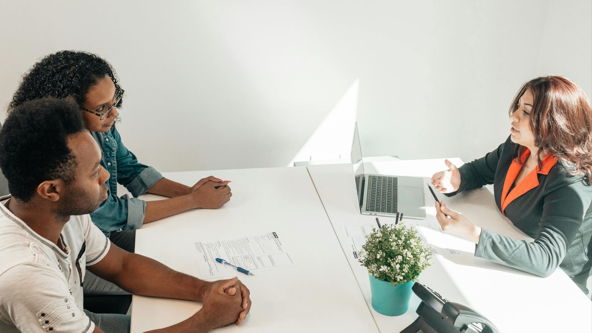 Two adults consulting a legal advisor in a modern office setting.