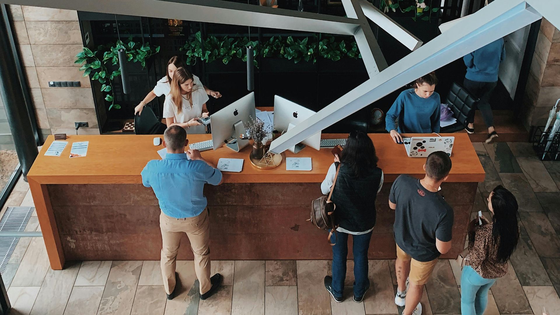 Aerial view of a modern hotel reception with people interacting at the desk in Sosnivka, Ukraine.